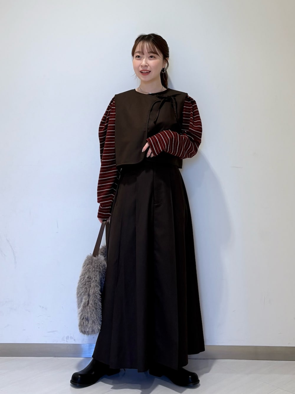 ブラウン系のワンピース、ブラック系のブーツ、レッド系のカーディガン/ボレロを着用したレディースの秋コーディネートの2枚目の写真