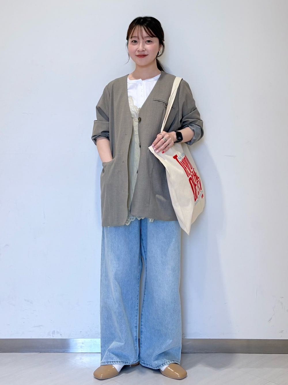 ホワイト系のTシャツ/カットソー、グレー系のノーカラージャケット、ブルー系のデニムパンツを着用したレディースの春コーディネートの3枚目の写真