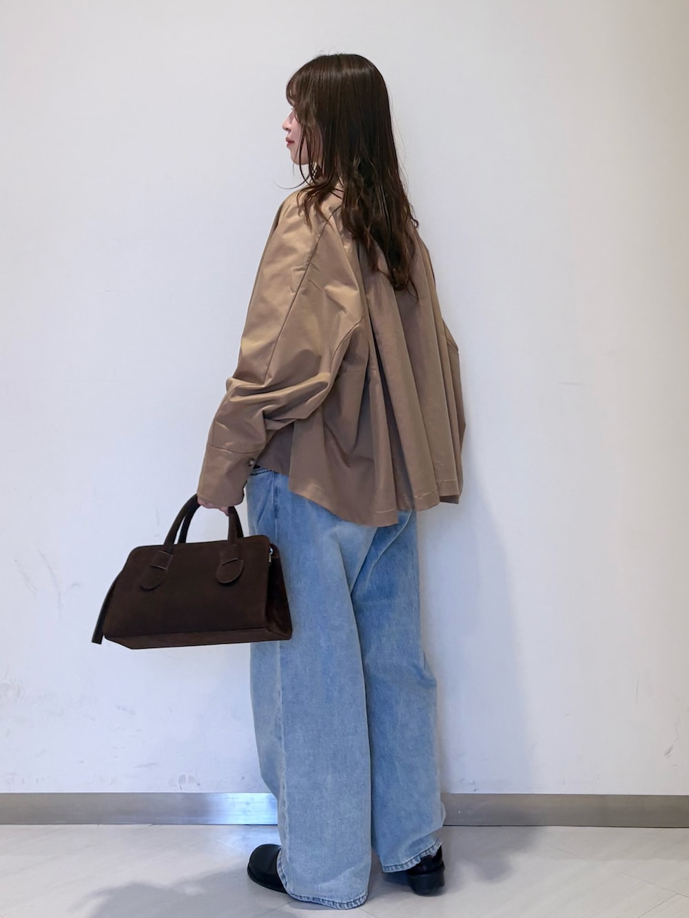 ブラック系のその他シューズ、ベージュ系のステンカラーコート、レッド系のニット/セーターを着用したレディースの春コーディネートの2枚目の写真