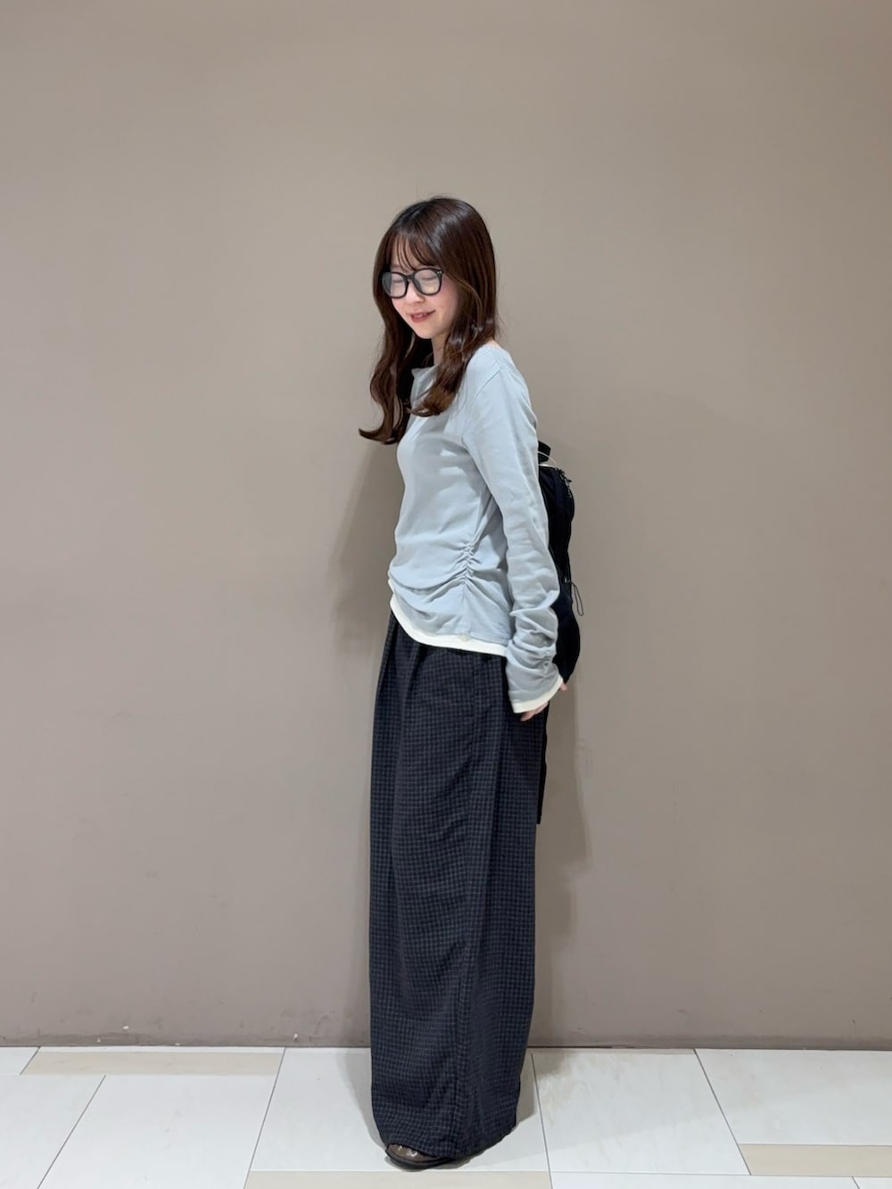 ブラウン系のローファー、グレー系のその他パンツ、ブラック系のバックパック/リュックを着用したレディースの秋コーディネートの2枚目の写真