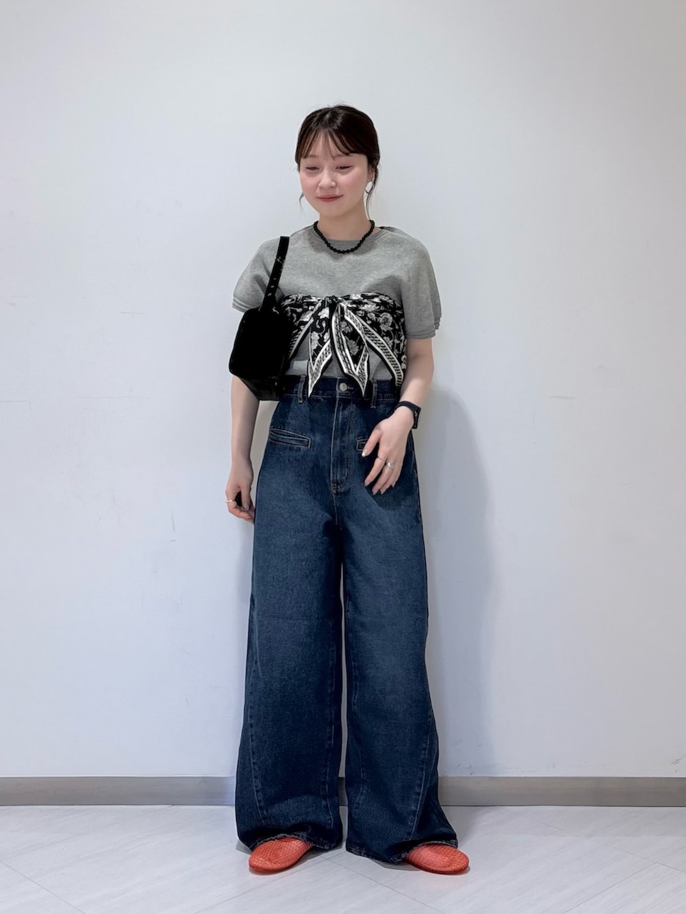 グレー系のニット/セーター、ブルー系のデニムパンツ、ブラック系のトートバッグを着用したレディースの春コーディネートの4枚目の写真