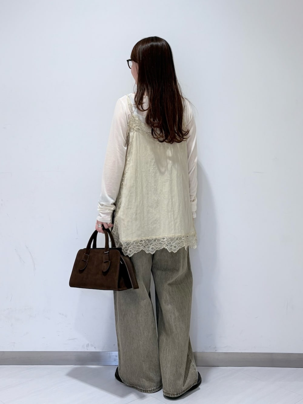 ホワイト系のTシャツ/カットソー、ベージュ系のキャミソール、ブラック系のその他シューズを着用したレディースの冬コーディネートの3枚目の写真