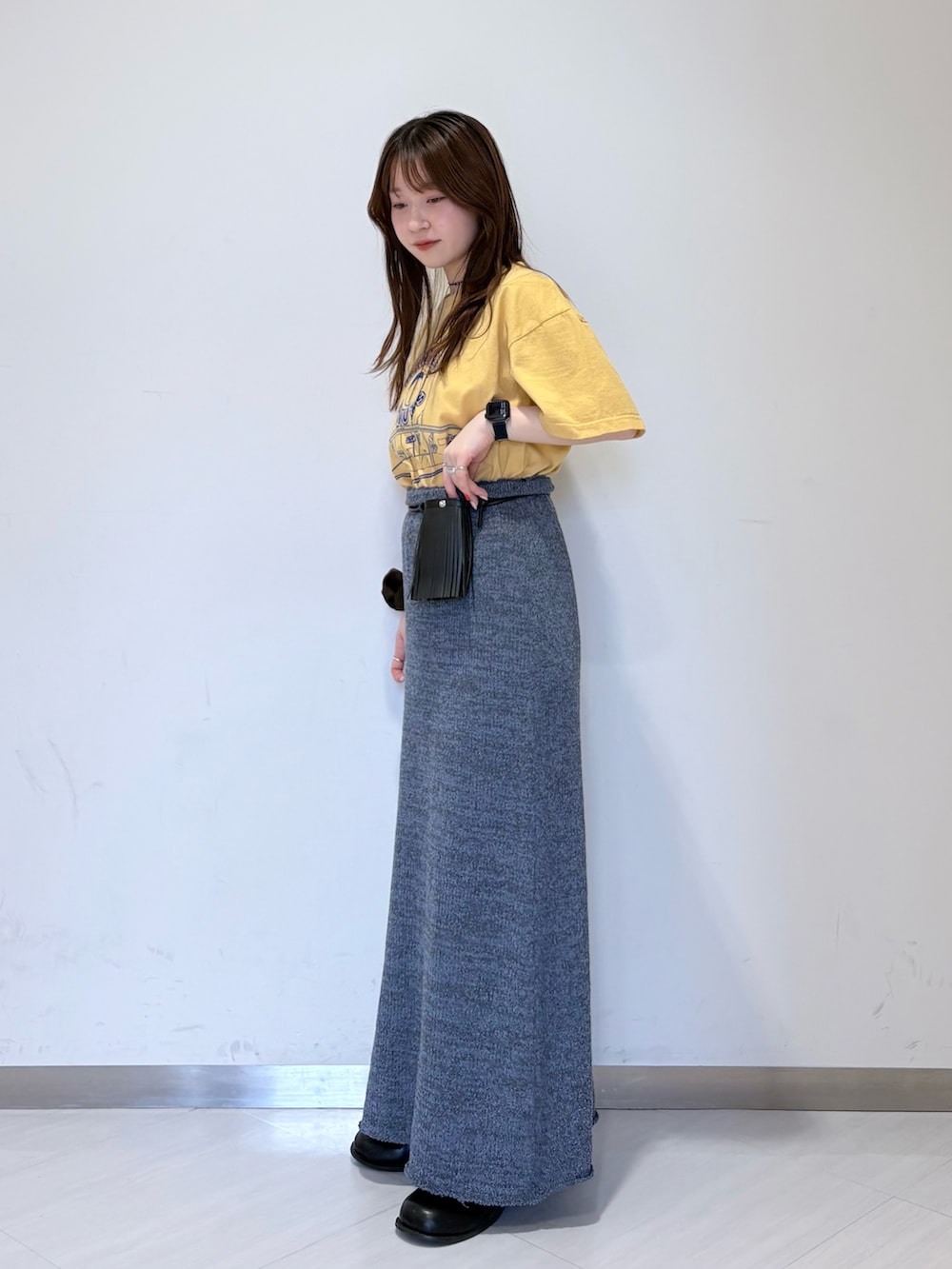 ブルー系のスカート、ブラック系のその他シューズ、イエロー系のTシャツ/カットソーを着用したレディースの春コーディネートの4枚目の写真