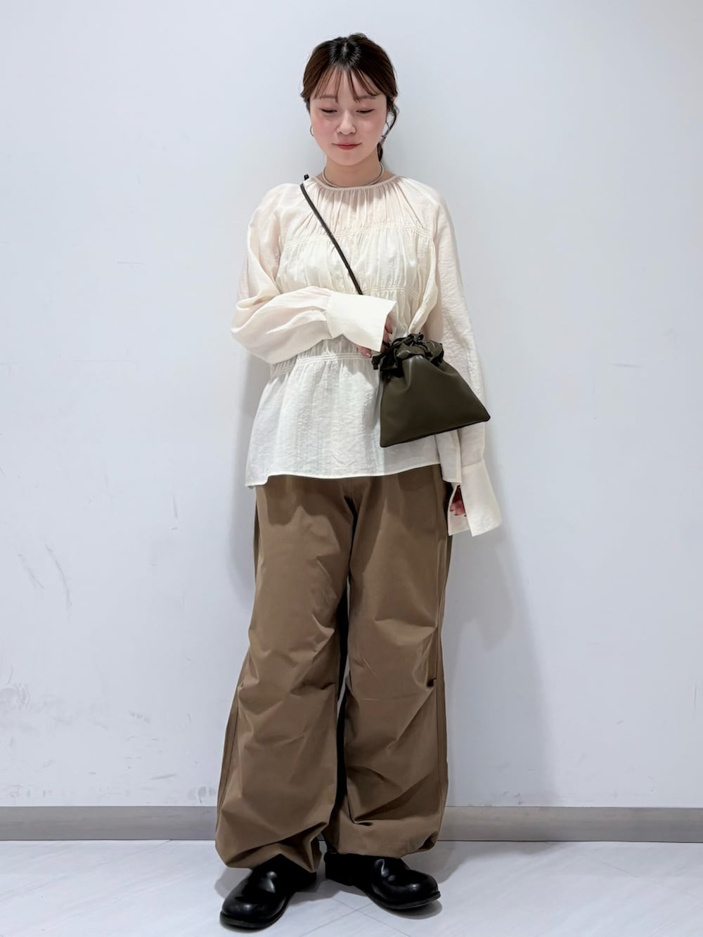 ホワイト系のシャツ/ブラウス、グリーン系のショルダーバッグ、グリーン系のその他パンツを着用したレディースの春コーディネートの3枚目の写真