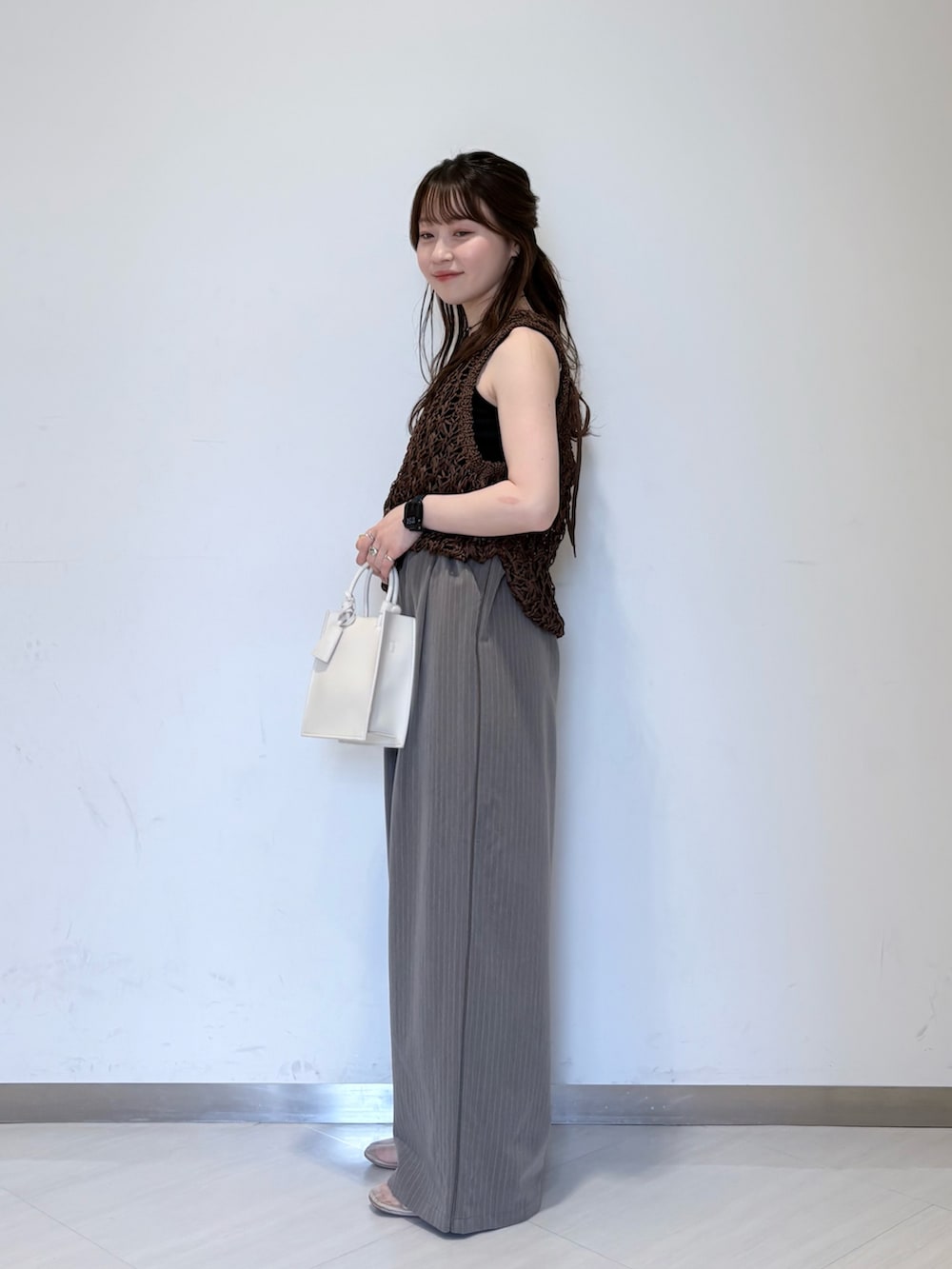 ホワイト系のニット/セーター、ブラウン系のその他パンツ、ブラック系のキャミソールを着用したレディースの春コーディネートの3枚目の写真