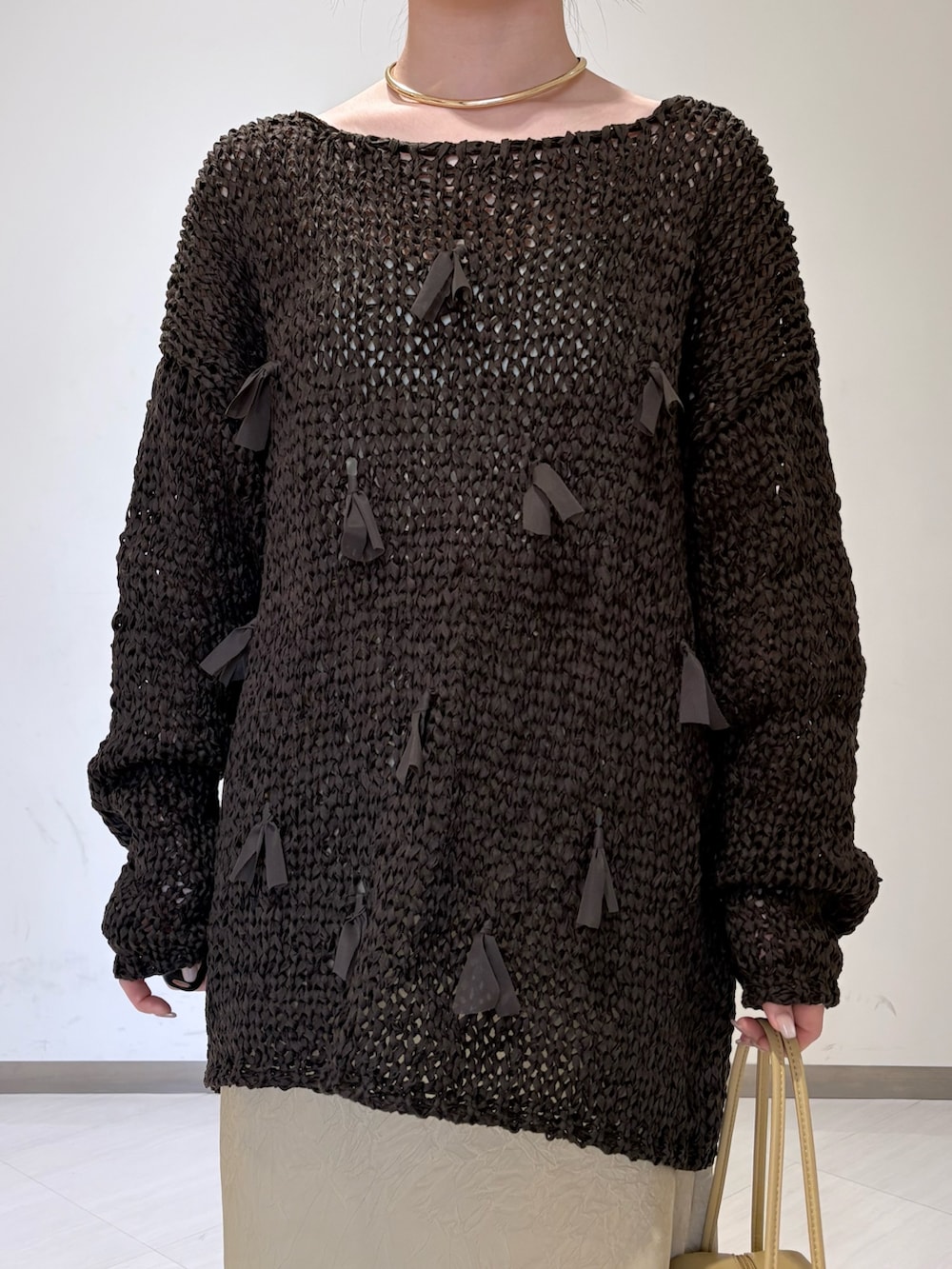 ベージュ系のスカート、ブラウン系のニット/セーター、ベージュ系のショルダーバッグを着用したレディースの冬コーディネートの4枚目の写真