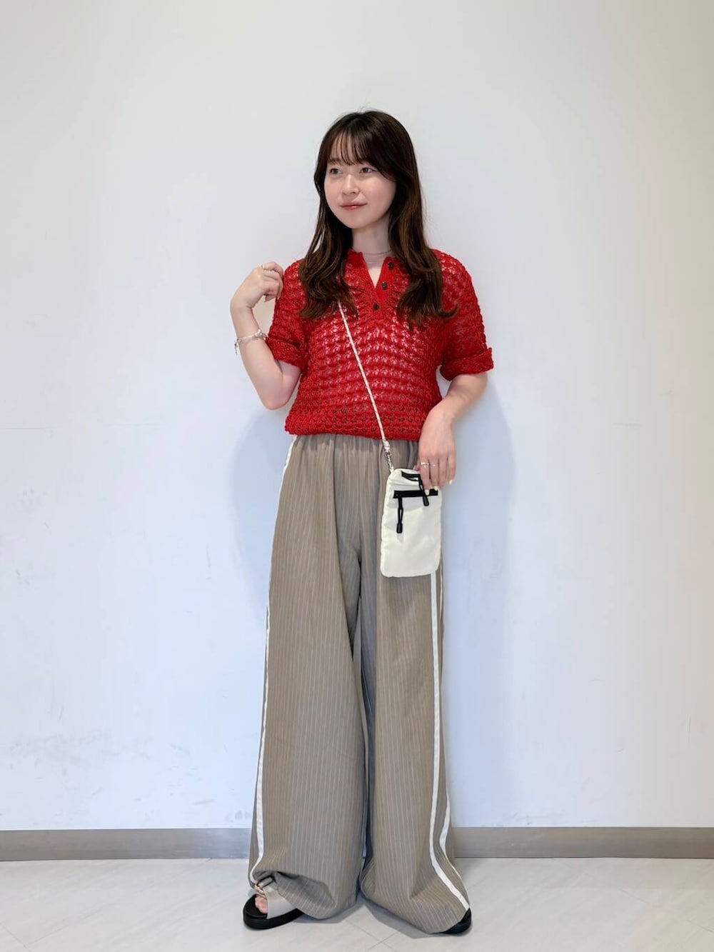 ホワイト系のショルダーバッグ、グレー系のサンダル、ベージュ系のその他パンツを着用したレディースの夏コーディネートの2枚目の写真