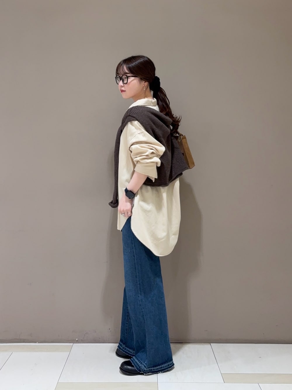 ブルー系のデニムパンツ、ベージュ系のシャツ/ブラウス、ブラウン系のニット/セーターを着用したレディースの秋コーディネートの2枚目の写真