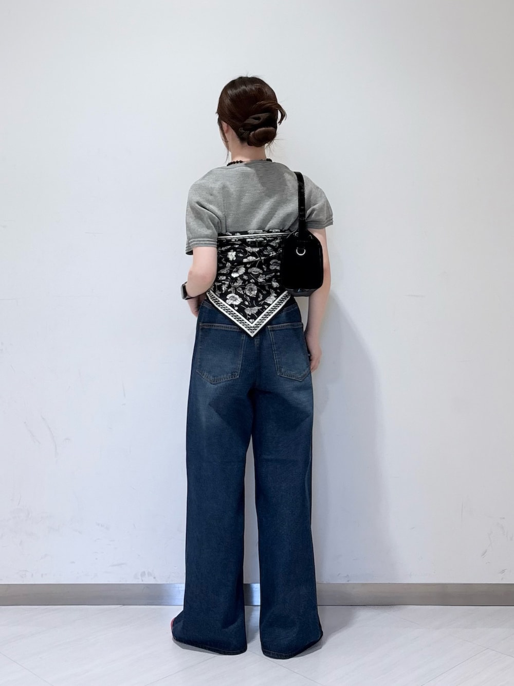 グレー系のニット/セーター、ブルー系のデニムパンツ、ブラック系のトートバッグを着用したレディースの春コーディネートの3枚目の写真