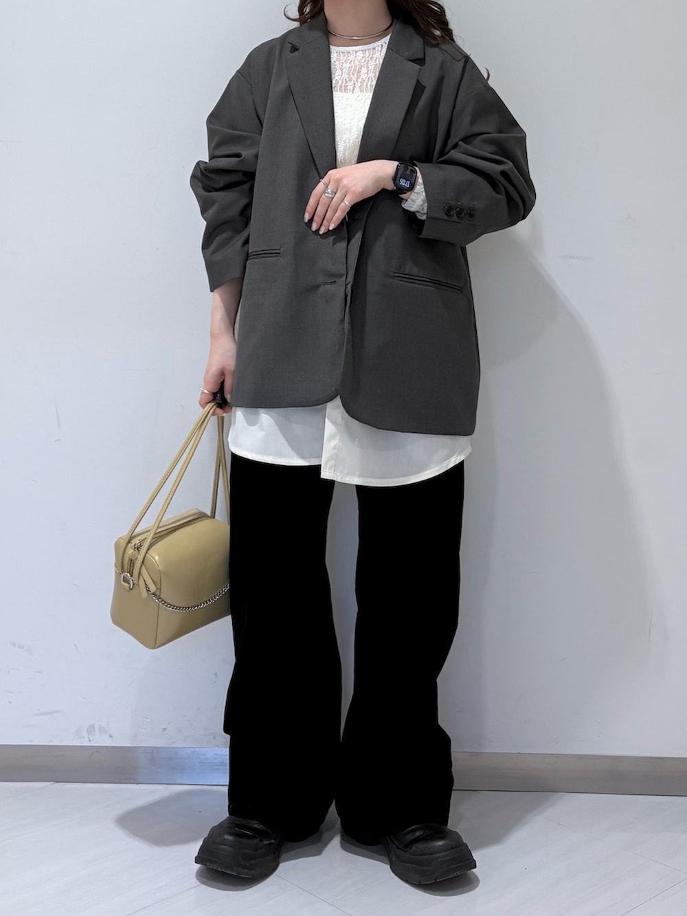 ベージュ系のショルダーバッグ、ブラック系のデニムパンツ、ホワイト系のTシャツ/カットソーを着用したレディースの冬コーディネートの3枚目の写真