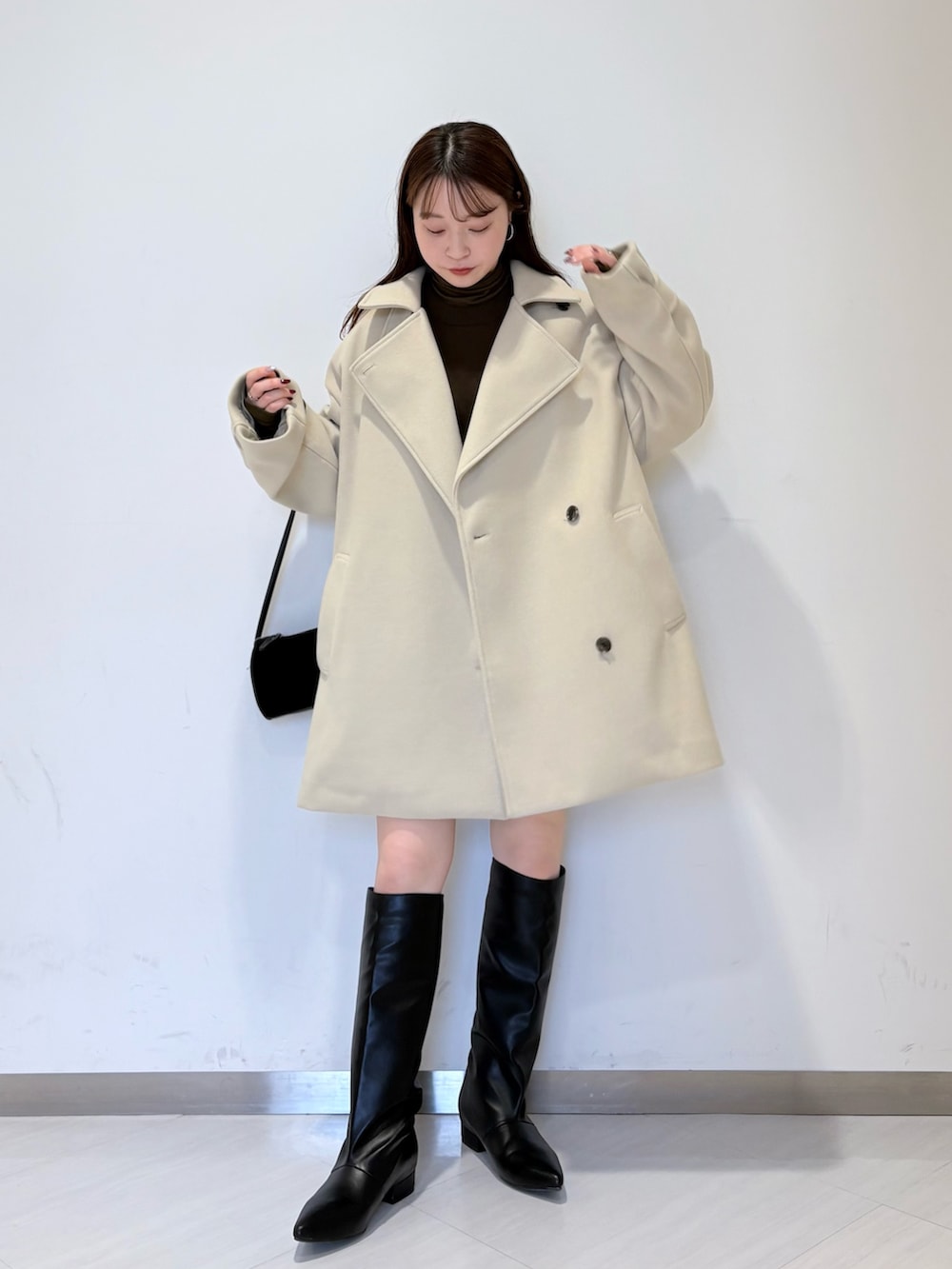 ベージュ系のその他アウター、グリーン系のニット/セーター、ブラウン系のその他パンツを着用したレディースの冬コーディネートの3枚目の写真