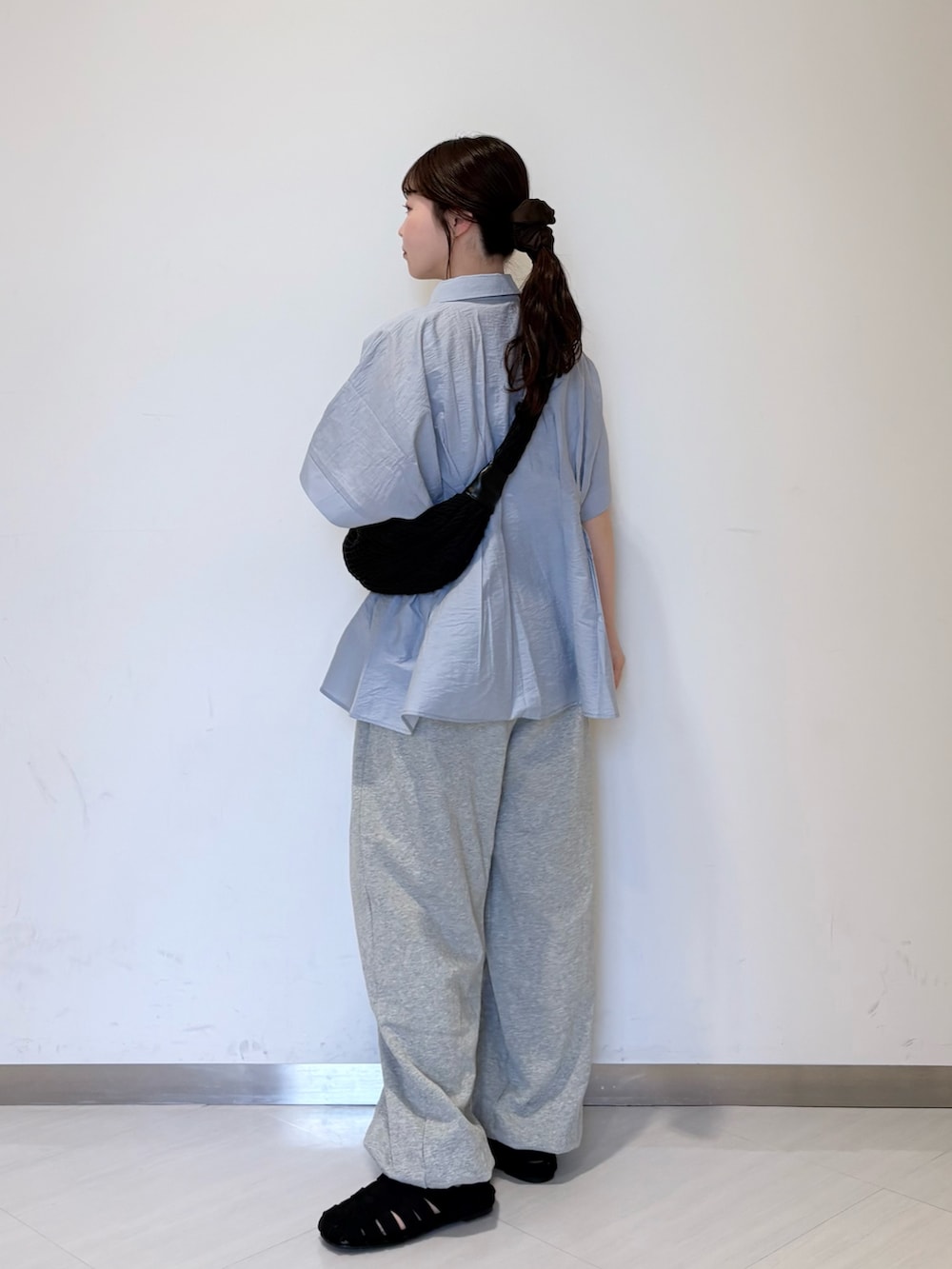 ブルー系のシャツ/ブラウス、ブラック系のショルダーバッグ、グレー系のその他パンツを着用したレディースの春コーディネートの3枚目の写真
