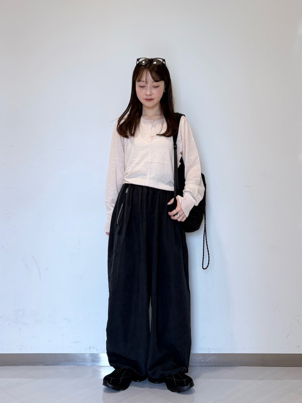 ピンク系のカーディガン/ボレロ、グレー系のその他パンツ、ブラック系のバックパック/リュックを着用したレディースの夏コーディネートの3枚目の写真