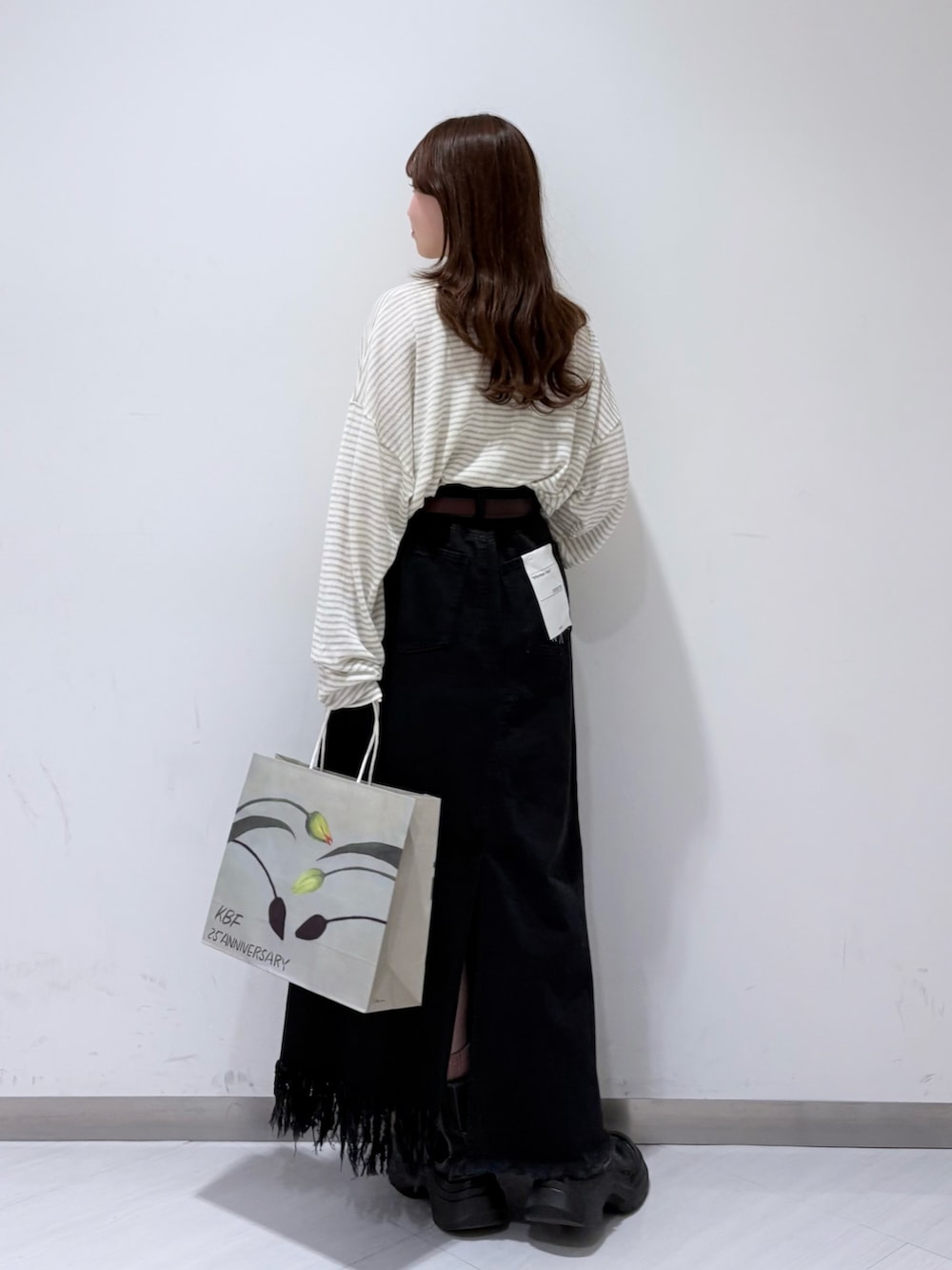 ホワイト系のニット/セーター、ブラック系のスカート、ブラウン系のベルトを着用したレディースの冬コーディネートの3枚目の写真