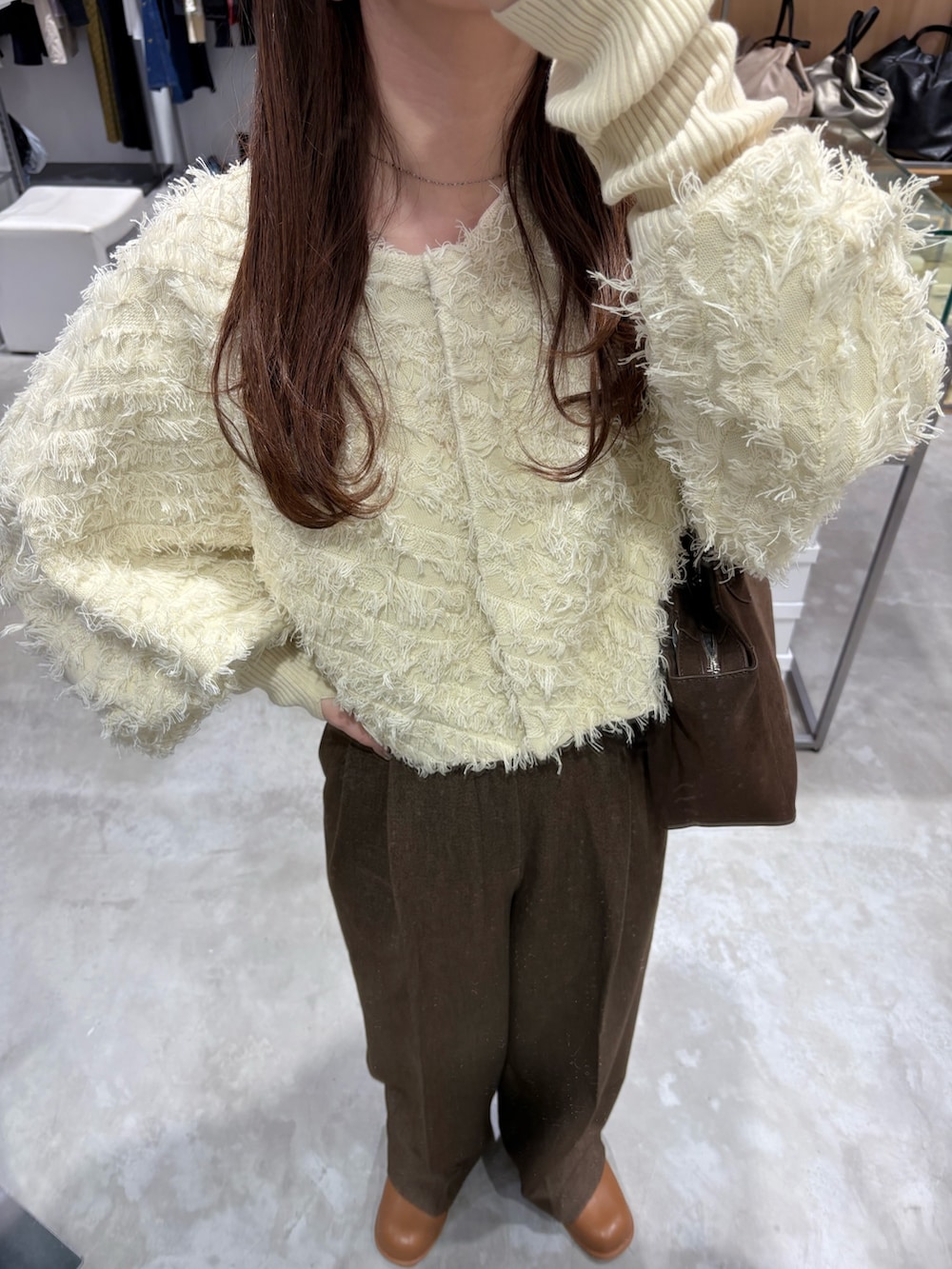 ホワイト系のカーディガン/ボレロ、ブラウン系のその他パンツ、ブラウン系のボストンバッグを着用したレディースの冬コーディネートの5枚目の写真