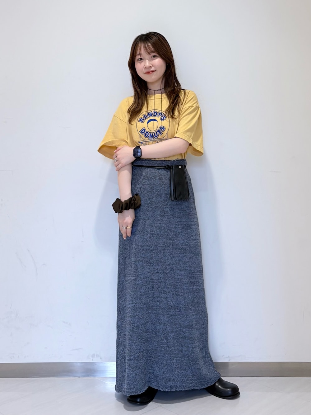 ブルー系のスカート、ブラック系のその他シューズ、イエロー系のTシャツ/カットソーを着用したレディースの春コーディネートの5枚目の写真