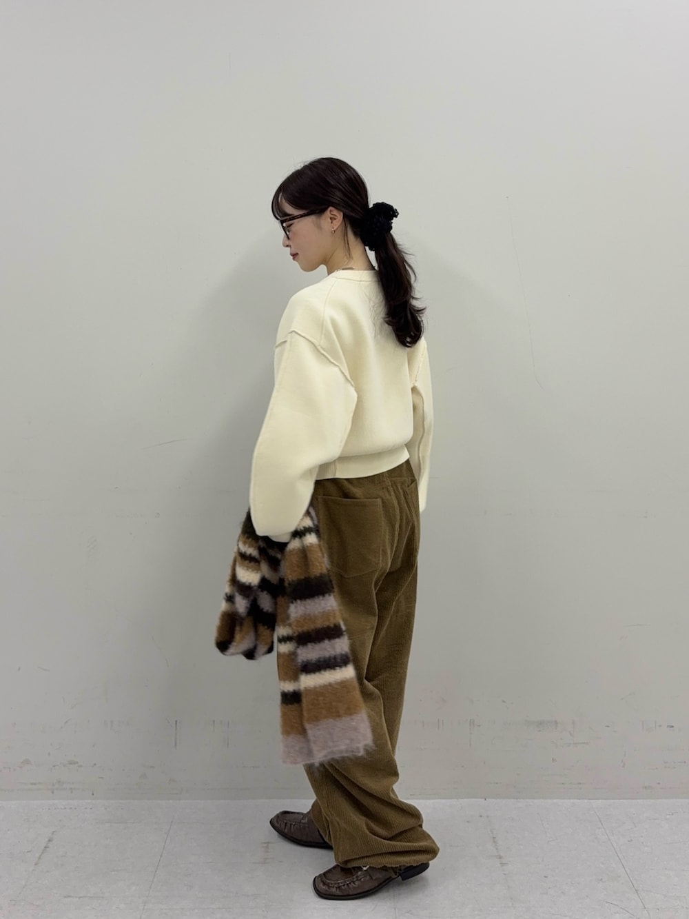 ホワイト系のニット/セーター、ブラウン系のその他パンツ、ブラウン系のローファーを着用したレディースの秋コーディネートの4枚目の写真