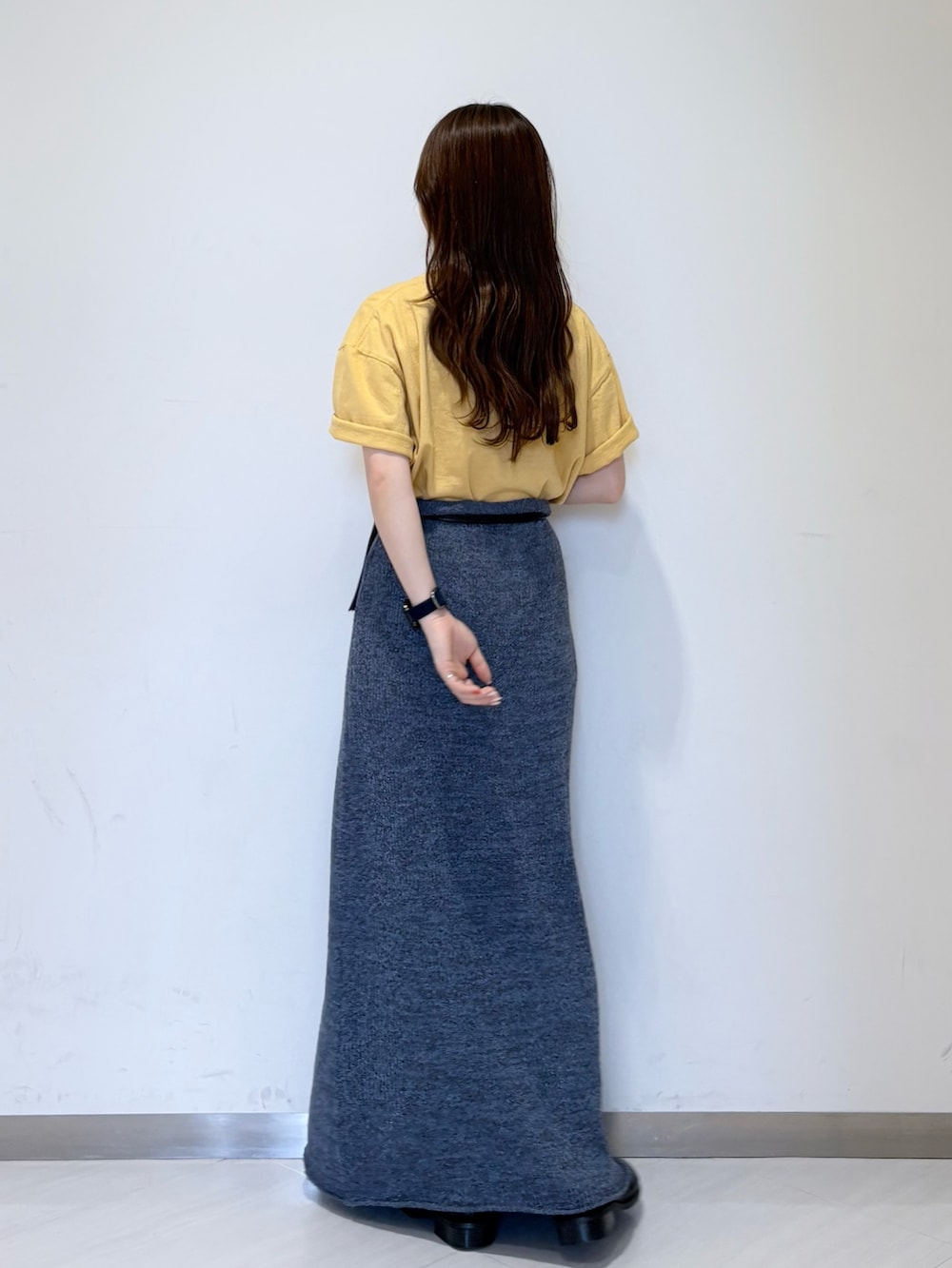 ブルー系のスカート、ブラック系のその他シューズ、イエロー系のTシャツ/カットソーを着用したレディースの春コーディネートの3枚目の写真