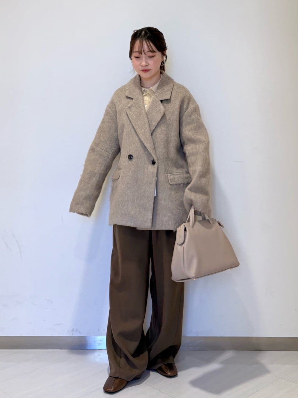 ホワイト系のニット/セーター、ブラウン系のその他パンツ、ブラウン系のその他アウターを着用したレディースの秋コーディネートの3枚目の写真