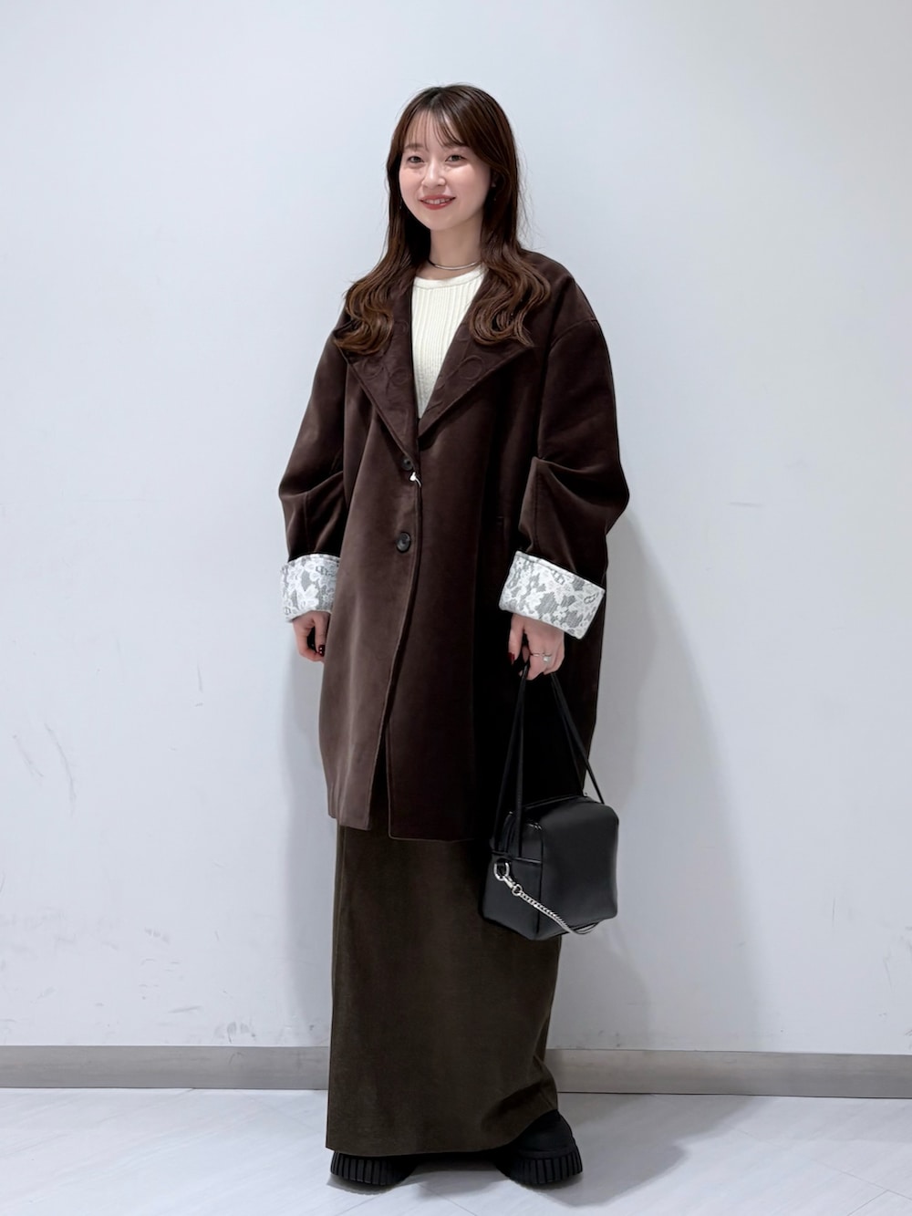 ブラウン系のその他アウター、ホワイト系のニット/セーター、ブラウン系のスカートを着用したレディースの冬コーディネートの4枚目の写真