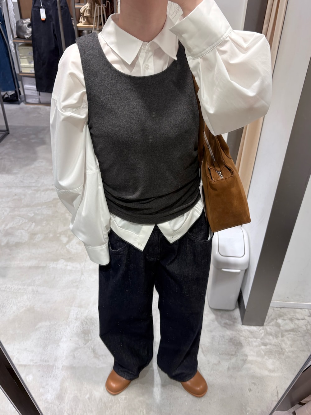 ホワイト系のシャツ/ブラウス、ブラウン系のブーツ、ブルー系のデニムパンツを着用したレディースの冬コーディネートの4枚目の写真