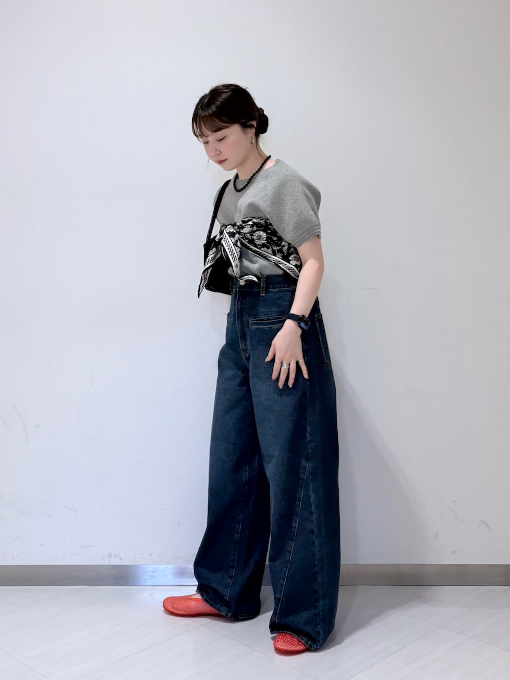 グレー系のニット/セーター、ブルー系のデニムパンツ、ブラック系のトートバッグを着用したレディースの春コーディネートの2枚目の写真
