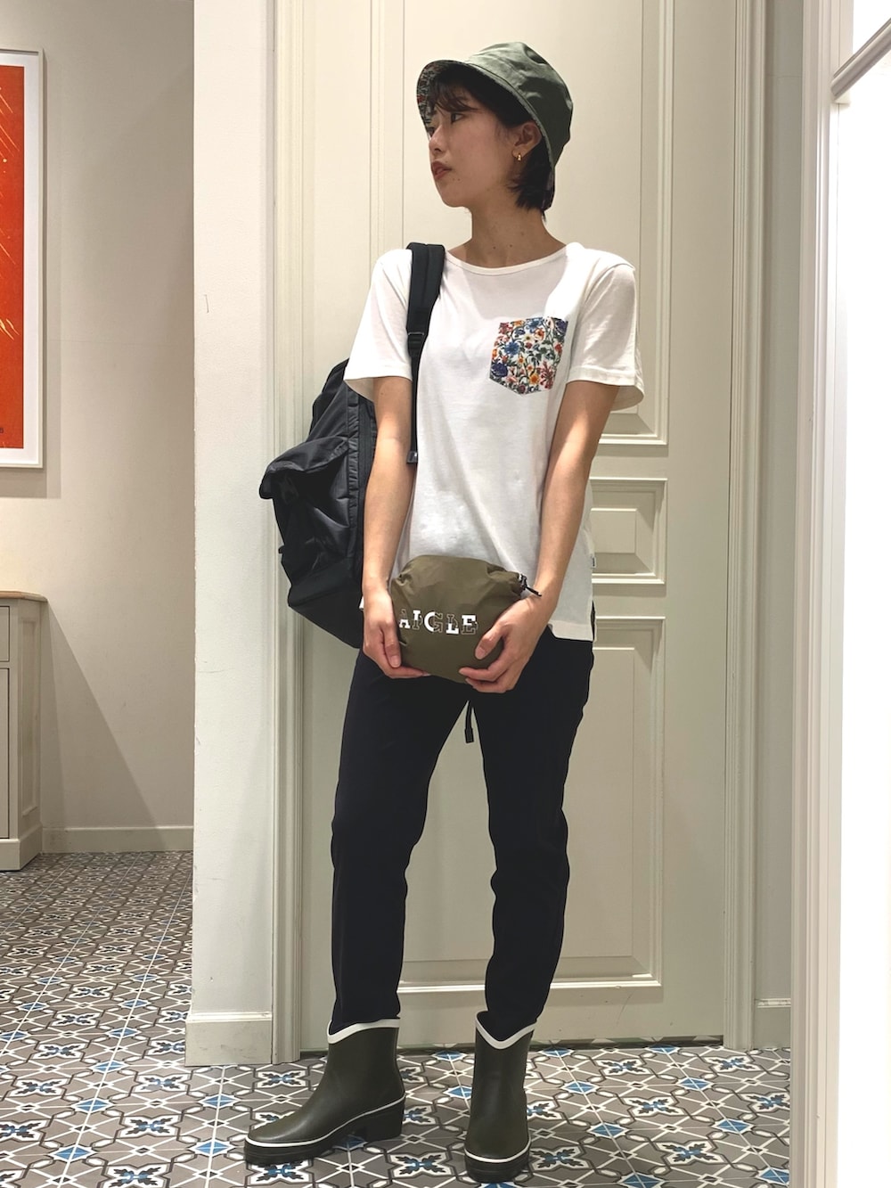 ブラック系のバックパック/リュック、ブラック系のその他パンツ、グリーン系のレインシューズを着用したレディースの春コーディネートの3枚目の写真