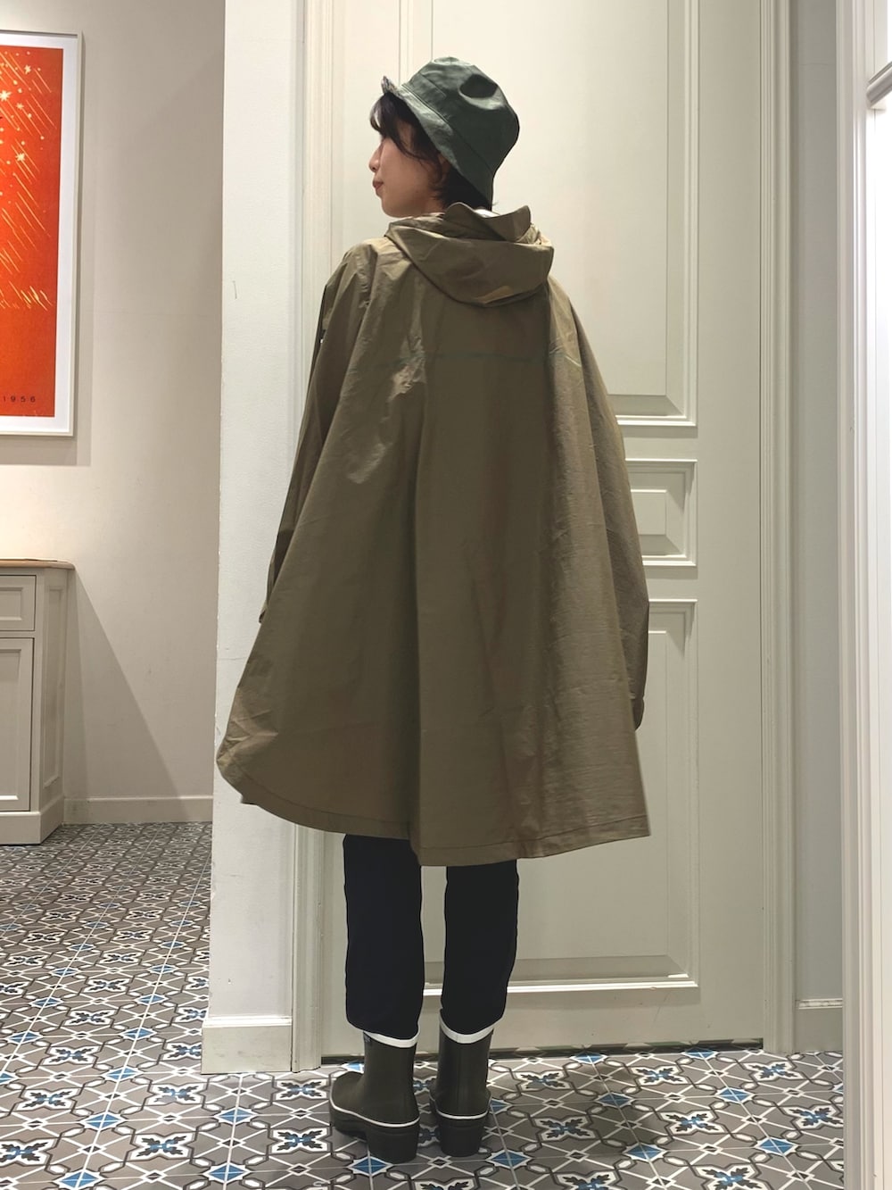 ブラック系のバックパック/リュック、ブラック系のその他パンツ、グリーン系のレインシューズを着用したレディースの春コーディネートの2枚目の写真