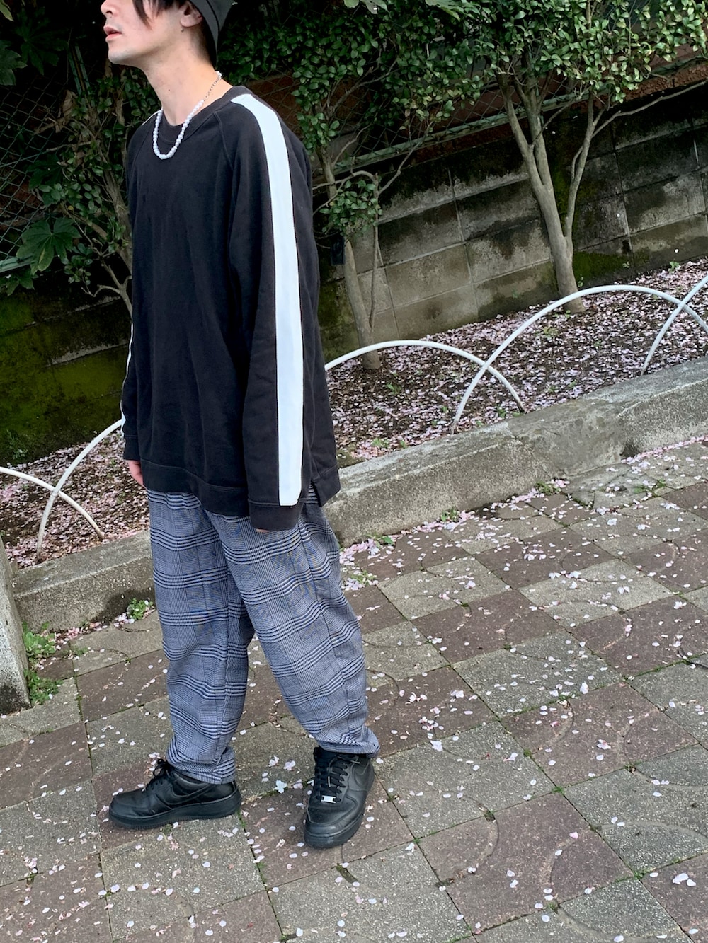 パープル系のスラックス、ホワイト系のスニーカー、ブラック系のスウェットを着用したメンズの春コーディネートの3枚目の写真