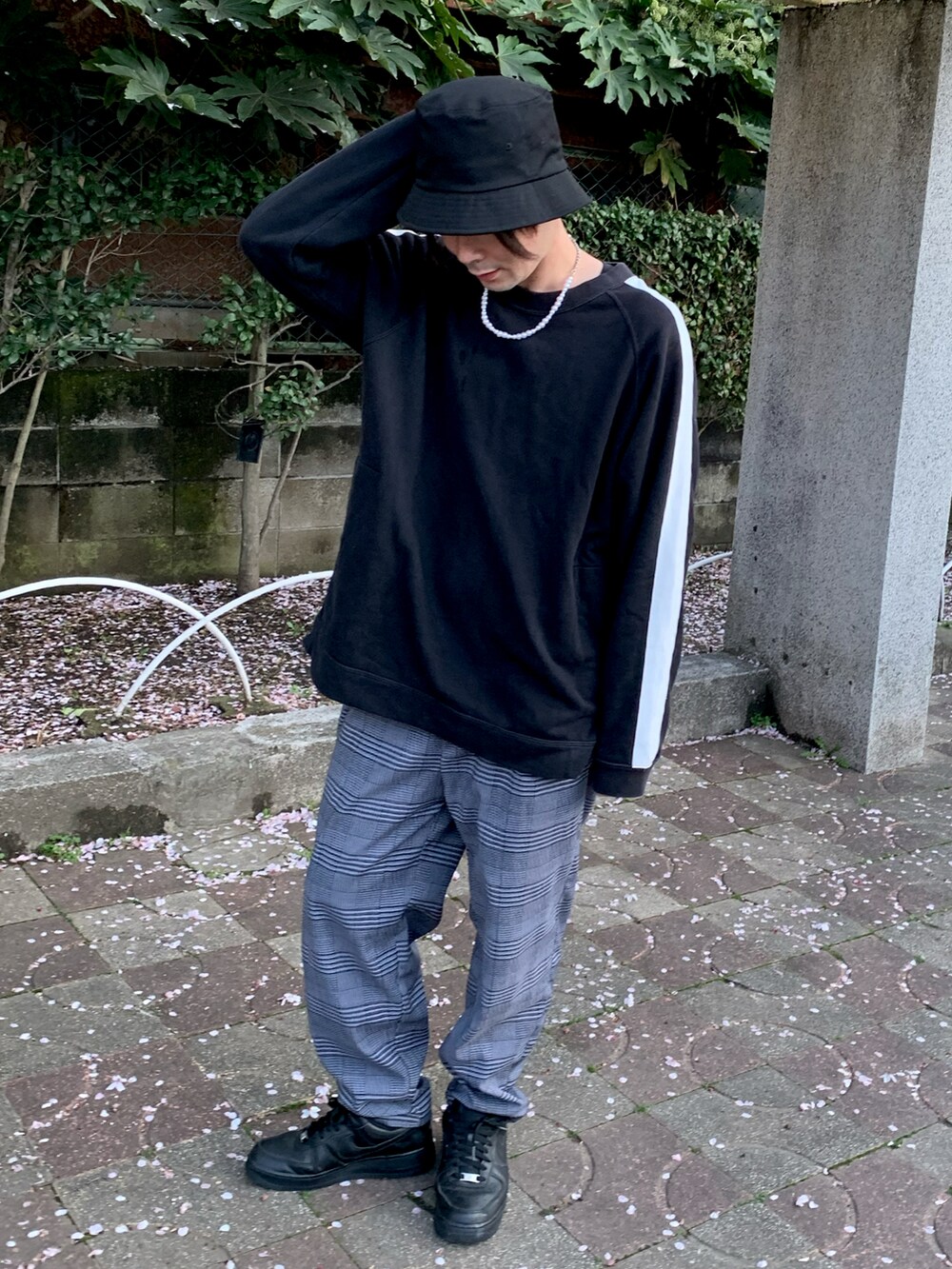 パープル系のスラックス、ホワイト系のスニーカー、ブラック系のスウェットを着用したメンズの春コーディネートの2枚目の写真