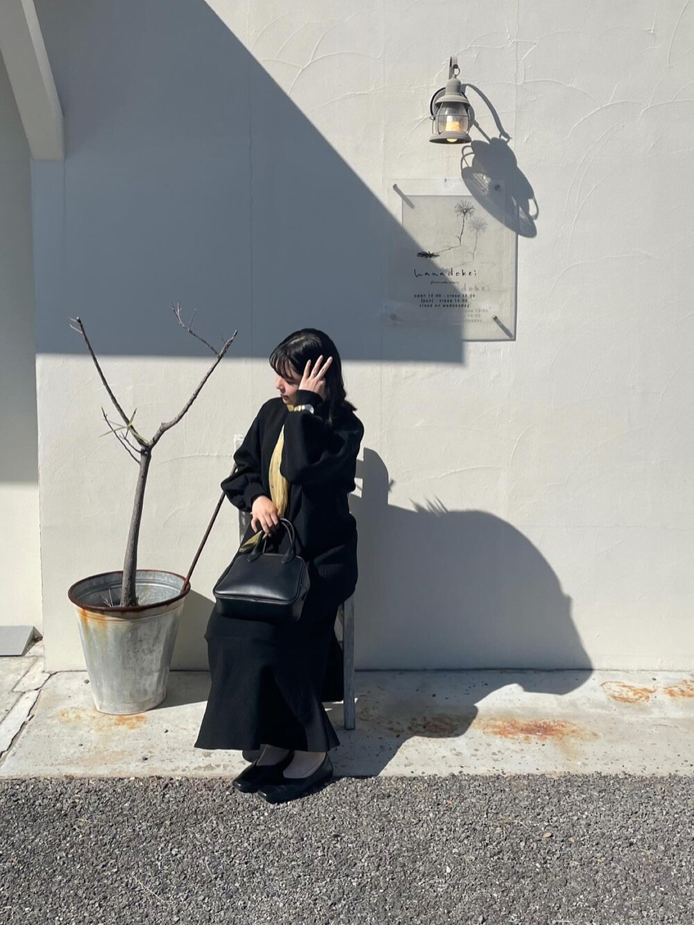 ブラック系のワンピース、ブラック系のパンプスを着用したレディースの秋コーディネートの2枚目の写真