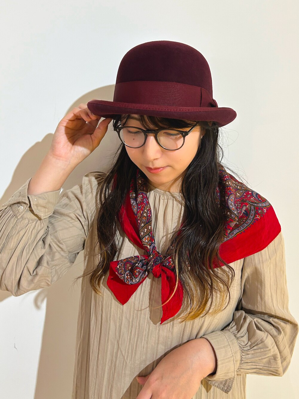 ベージュ系のワンピース、ブラック系のローファー、レッド系のハットを着用したレディースの秋コーディネートの2枚目の写真