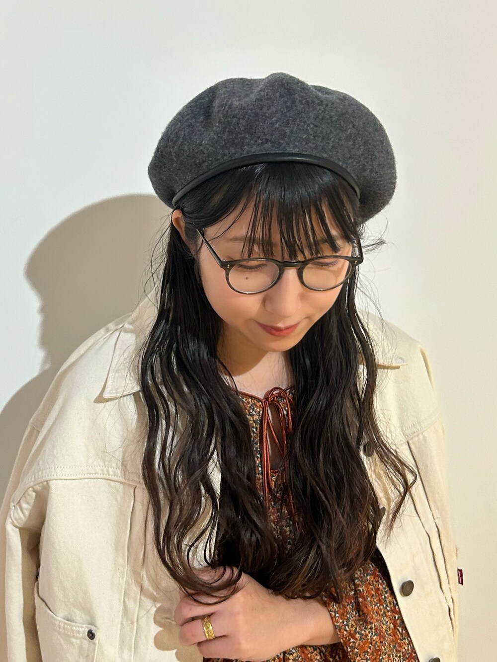 レッド系のブーツ、オレンジ系のワンピース、ホワイト系のデニムジャケットを着用したレディースの秋コーディネートの2枚目の写真