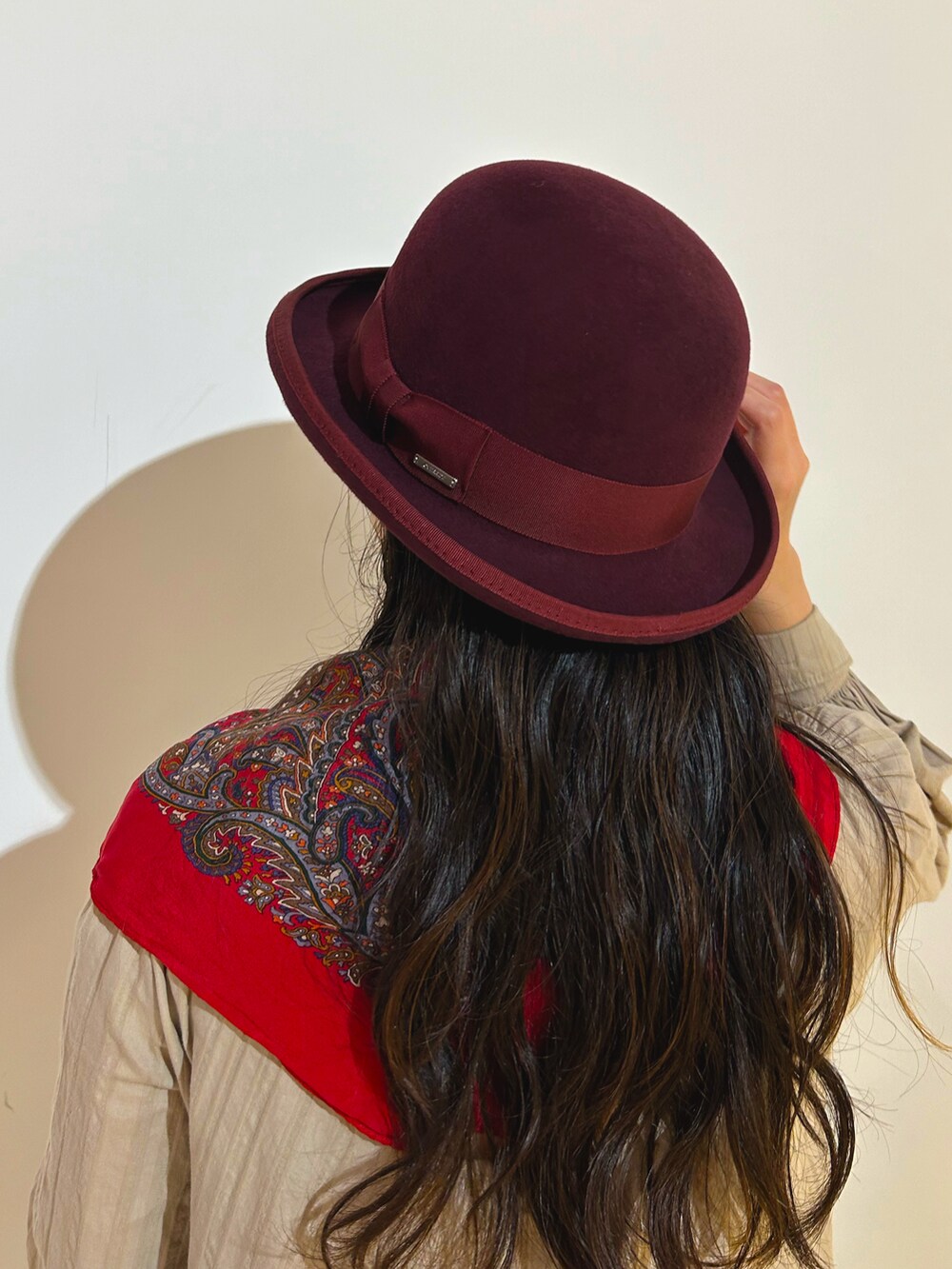 ベージュ系のワンピース、ブラック系のローファー、レッド系のハットを着用したレディースの秋コーディネートの3枚目の写真