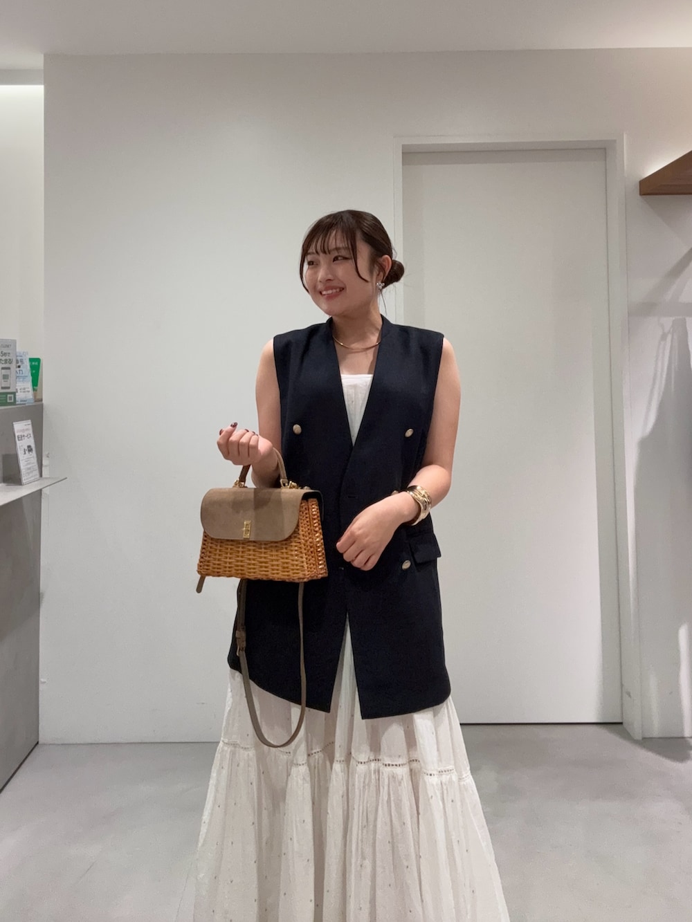 ブルー系のベスト、ホワイト系のワンピース、ブラック系のその他シューズを着用したレディースの夏コーディネートの3枚目の写真