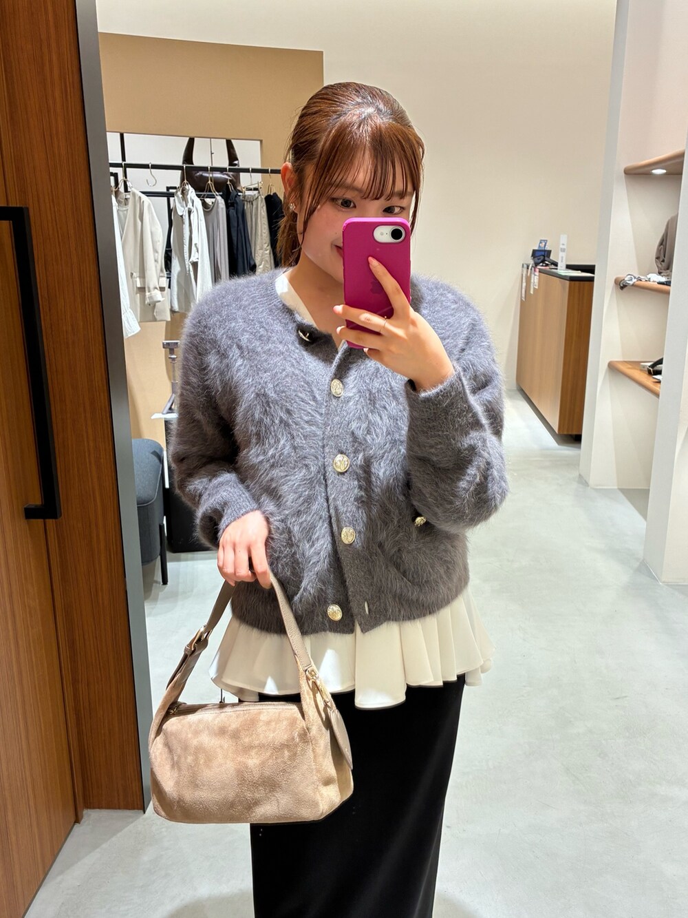 グレー系のニット/セーター、ホワイト系のシャツ/ブラウス、ブラック系のスカートを着用したレディースの秋コーディネートの2枚目の写真