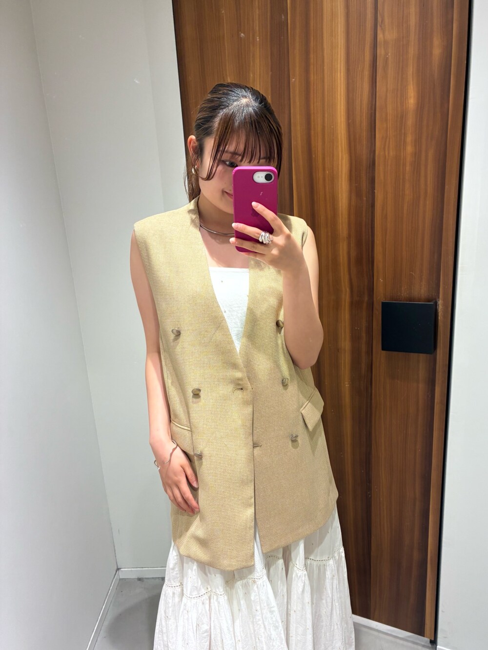 ベージュ系のベスト、ホワイト系のワンピース、ブラック系のその他シューズを着用したレディースの夏コーディネートの2枚目の写真