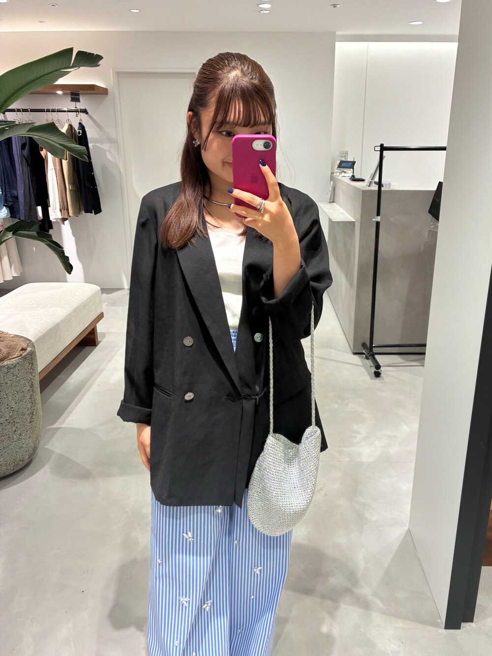 ブラック系のテーラードジャケット、ブルー系のその他パンツ、シルバー系のショルダーバッグを着用したレディースの夏コーディネートの3枚目の写真