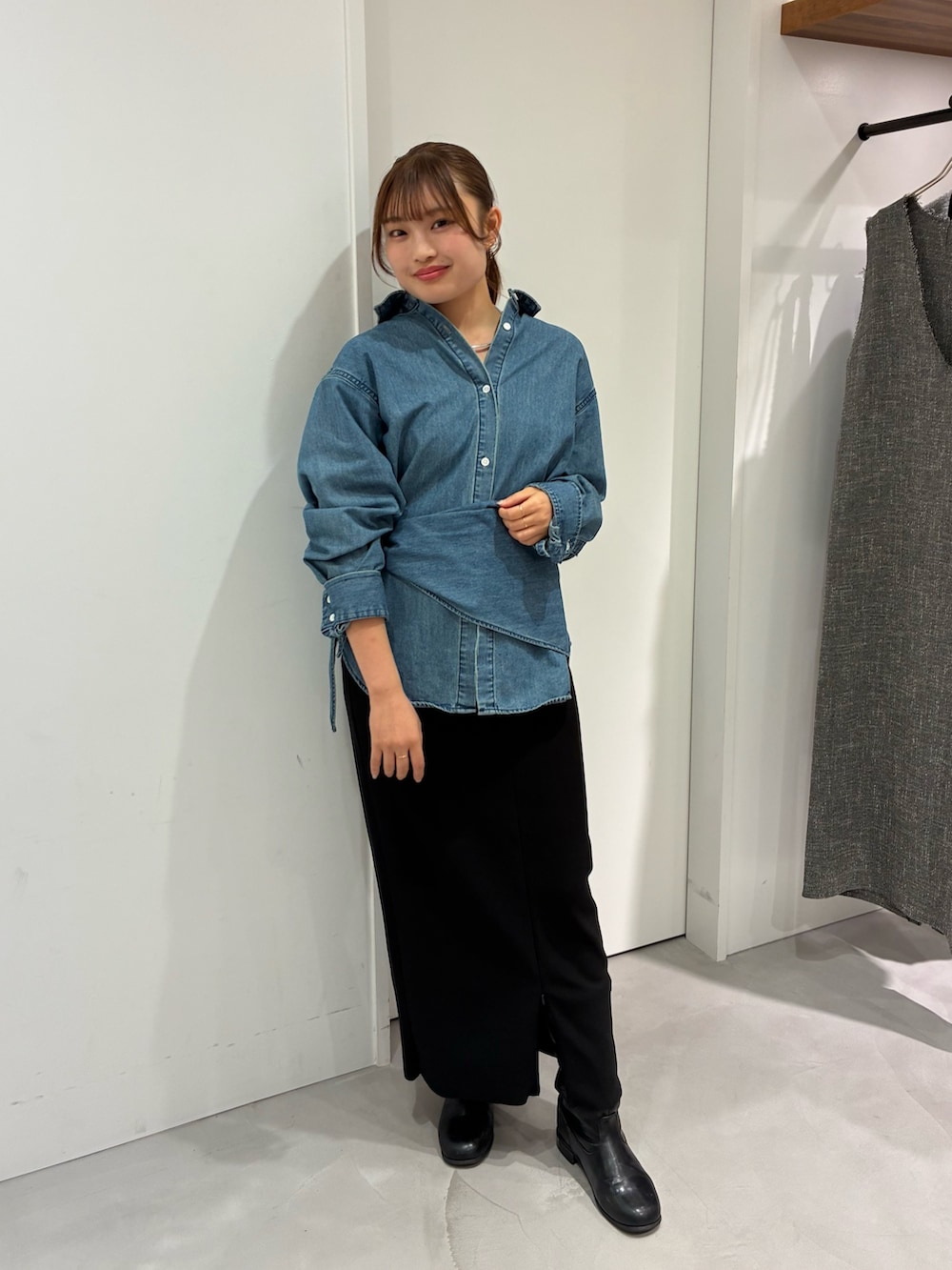 ブルー系のシャツ/ブラウス、ブラック系のスカート、ホワイト系のクラッチバッグを着用したレディースの秋コーディネートの5枚目の写真