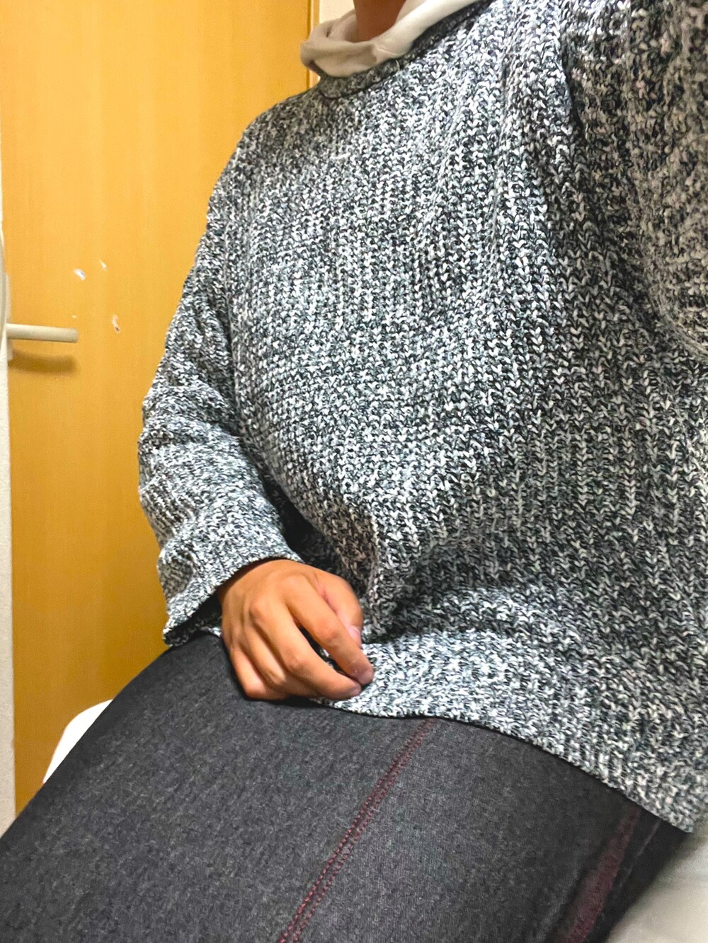 グレー系のニット/セーター、ベージュ系のバッグ、ブラック系のスニーカーを着用したメンズの秋コーディネートの3枚目の写真