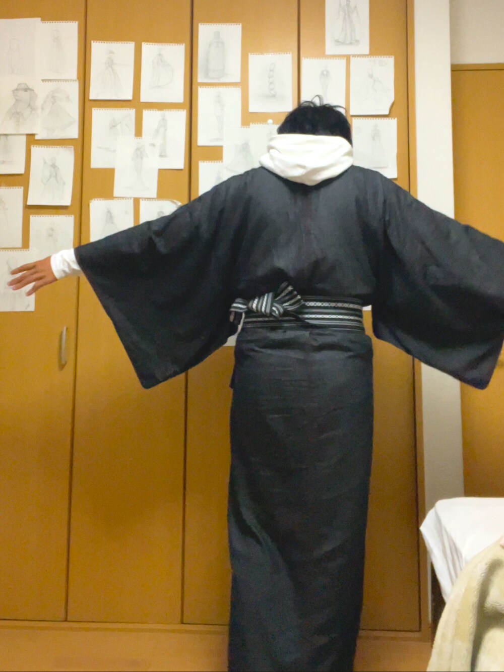 グレー系のニット/セーター、ベージュ系のバッグ、ブラック系のスニーカーを着用したメンズの秋コーディネートの2枚目の写真