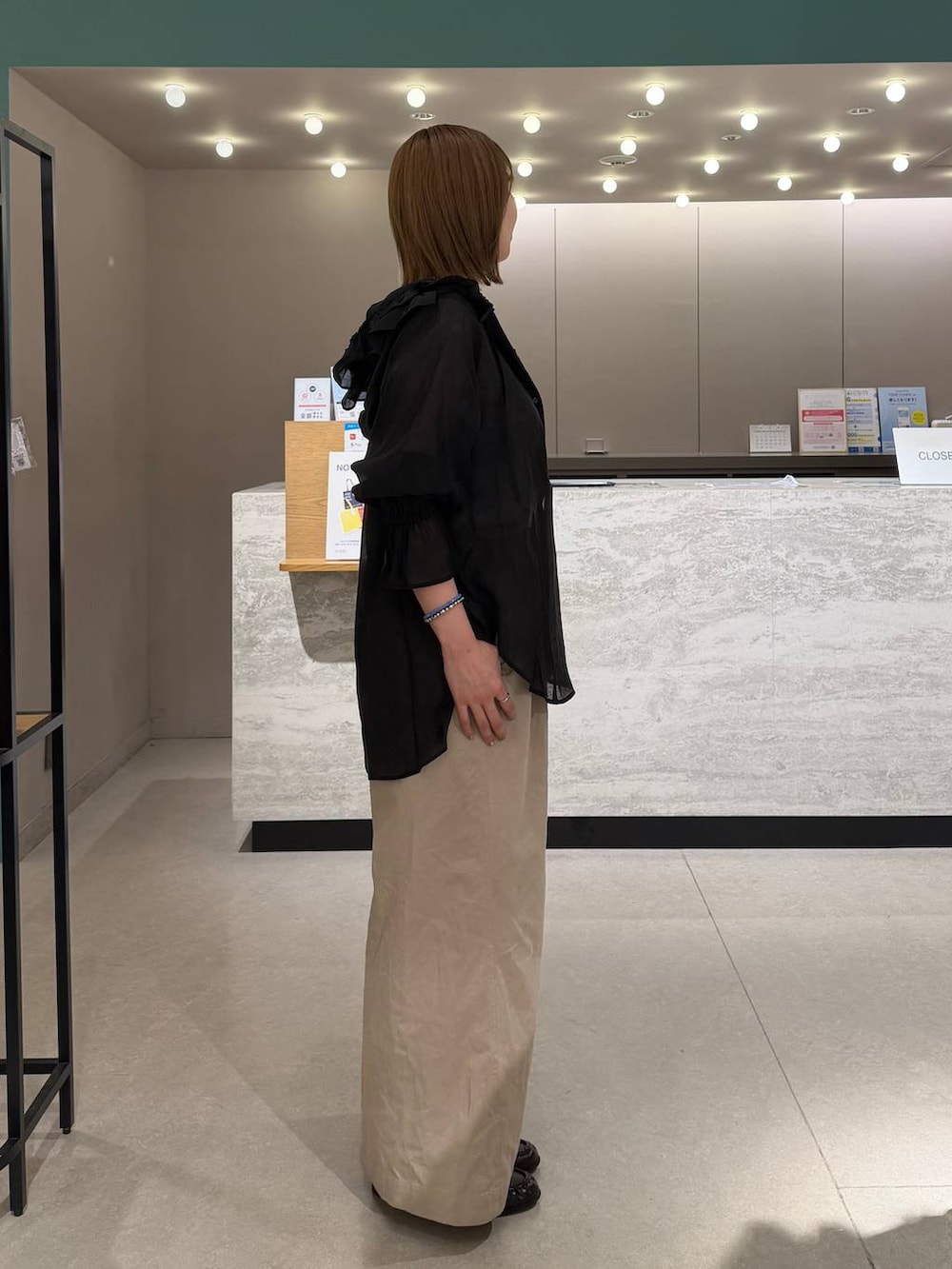 シルバー系のタンクトップ、ブラック系のシャツ/ブラウス、ブラック系のデニムパンツを着用したレディースの春コーディネートの3枚目の写真