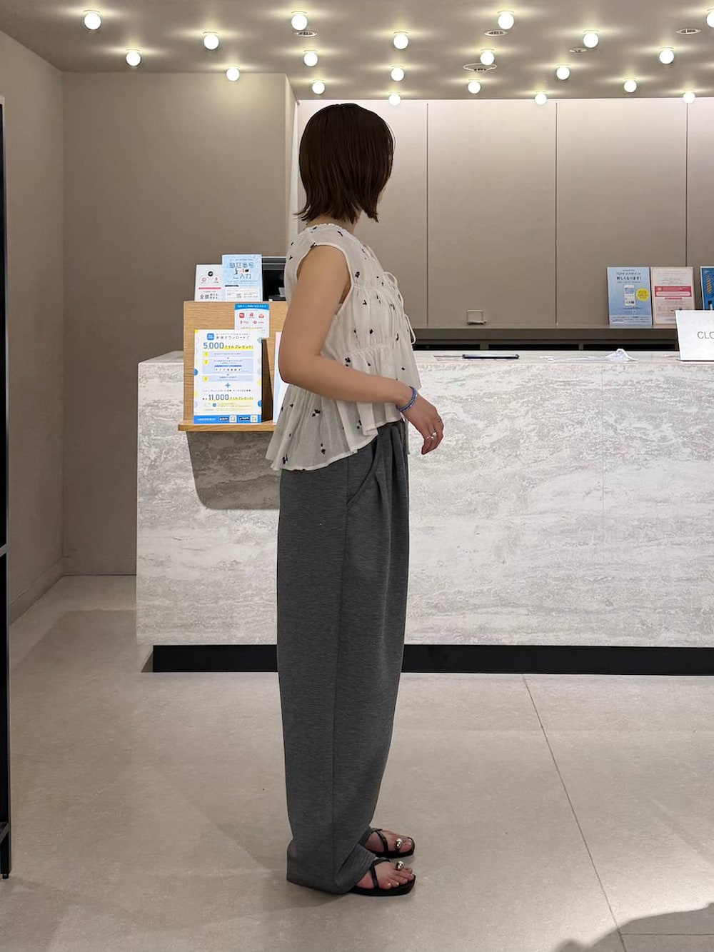 グレー系のスウェットパンツ、シルバー系のタンクトップ、ブラック系のサンダルを着用したレディースの夏コーディネートの3枚目の写真