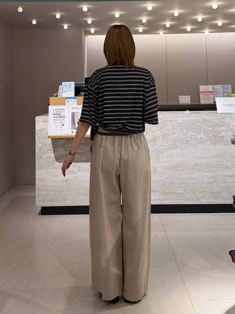 ベージュ系のデニムパンツ、ブラック系のローファー、ブラウン系のボディバッグ/ウエストポーチを着用したレディースの春コーディネートの3枚目の写真