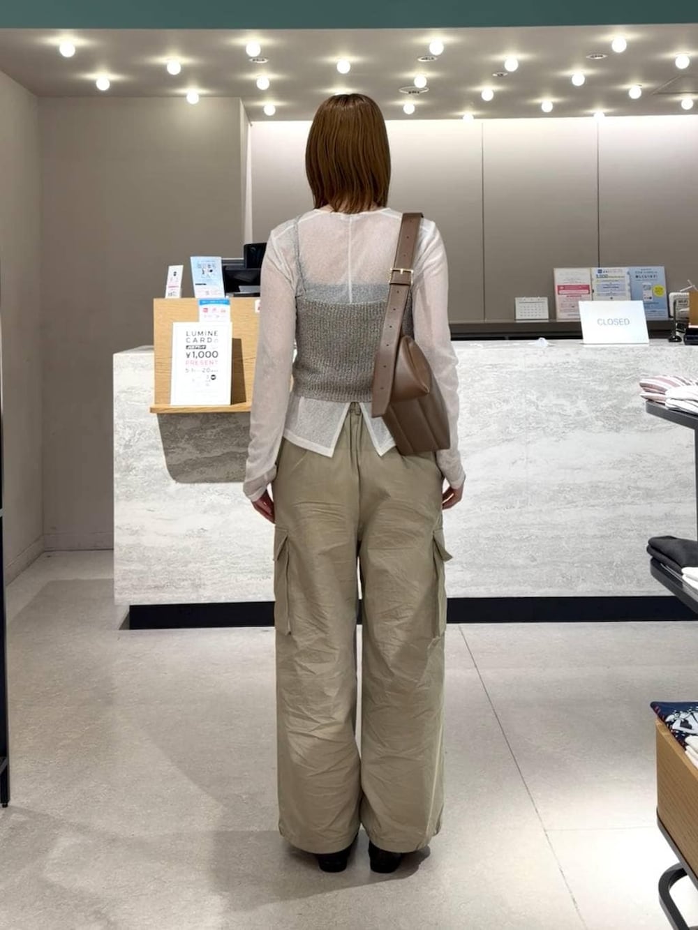 ブラック系のローファー、ホワイト系のTシャツ/カットソー、ブラウン系のショルダーバッグを着用したレディースの春コーディネートの3枚目の写真