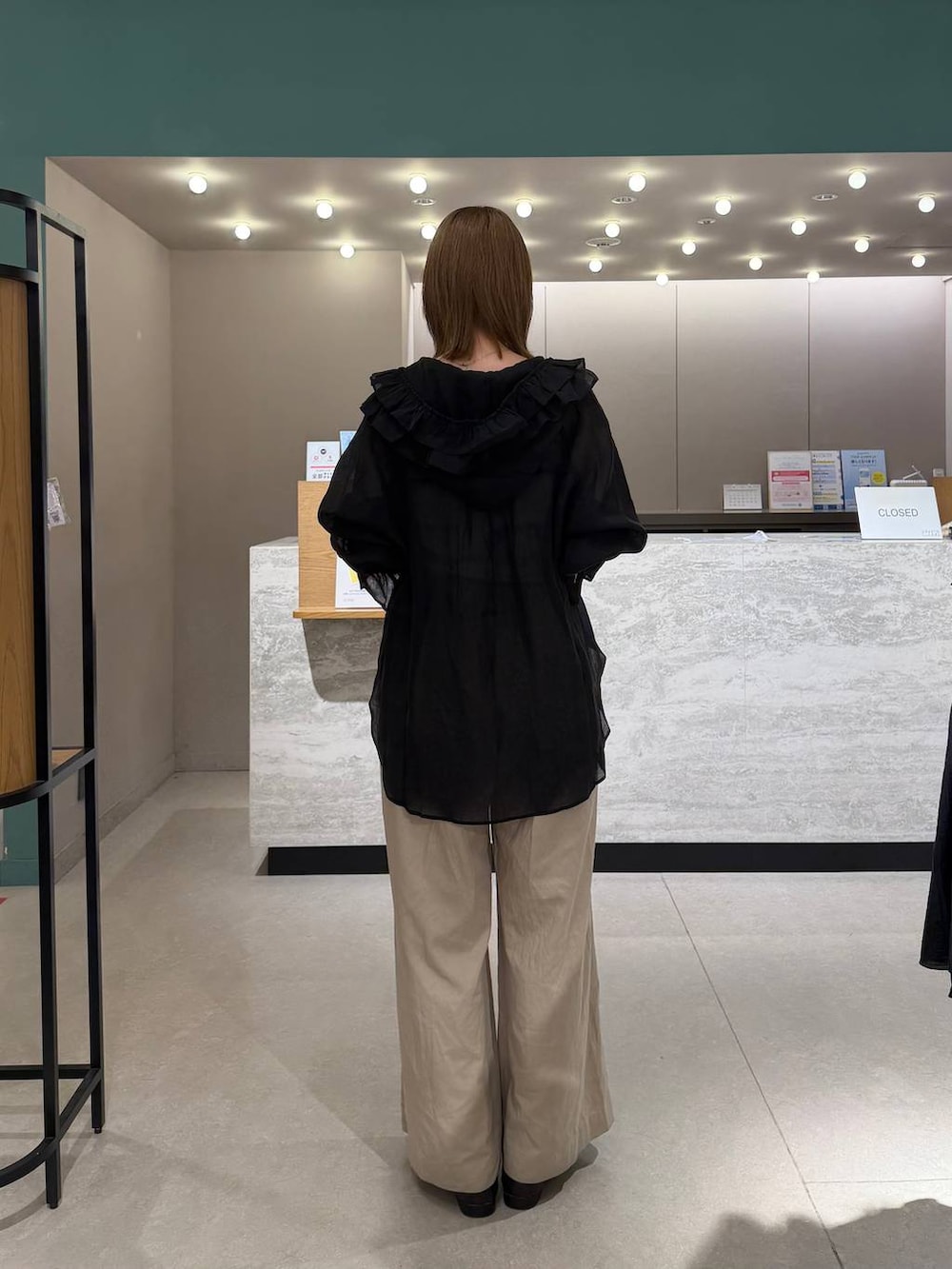 シルバー系のタンクトップ、ブラック系のシャツ/ブラウス、ブラック系のデニムパンツを着用したレディースの春コーディネートの2枚目の写真