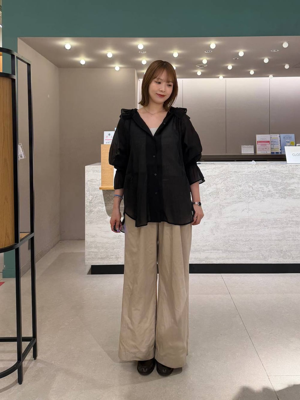 シルバー系のタンクトップ、ブラック系のシャツ/ブラウス、ブラック系のデニムパンツを着用したレディースの春コーディネートの4枚目の写真