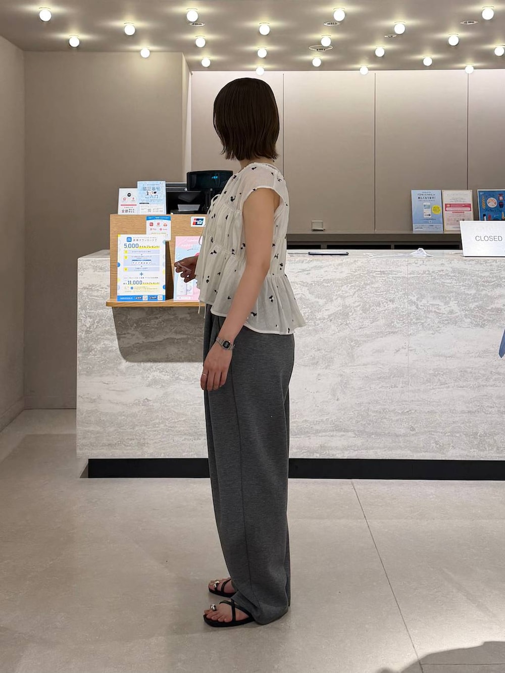 グレー系のスウェットパンツ、シルバー系のタンクトップ、ブラック系のサンダルを着用したレディースの夏コーディネートの2枚目の写真