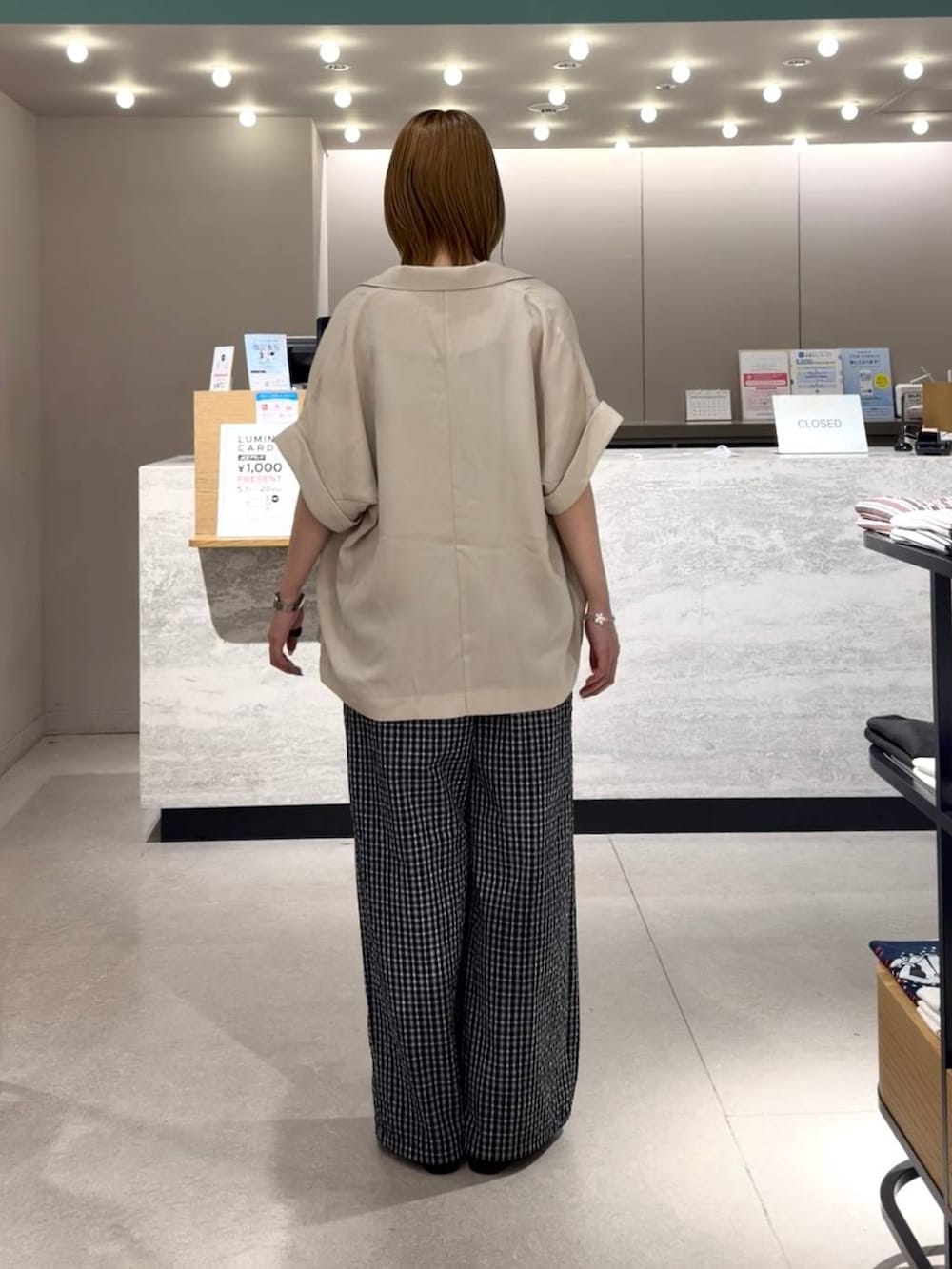 ホワイト系のテーラードジャケット、ブラック系のローファー、ブルー系のTシャツ/カットソーを着用したレディースの春コーディネートの3枚目の写真