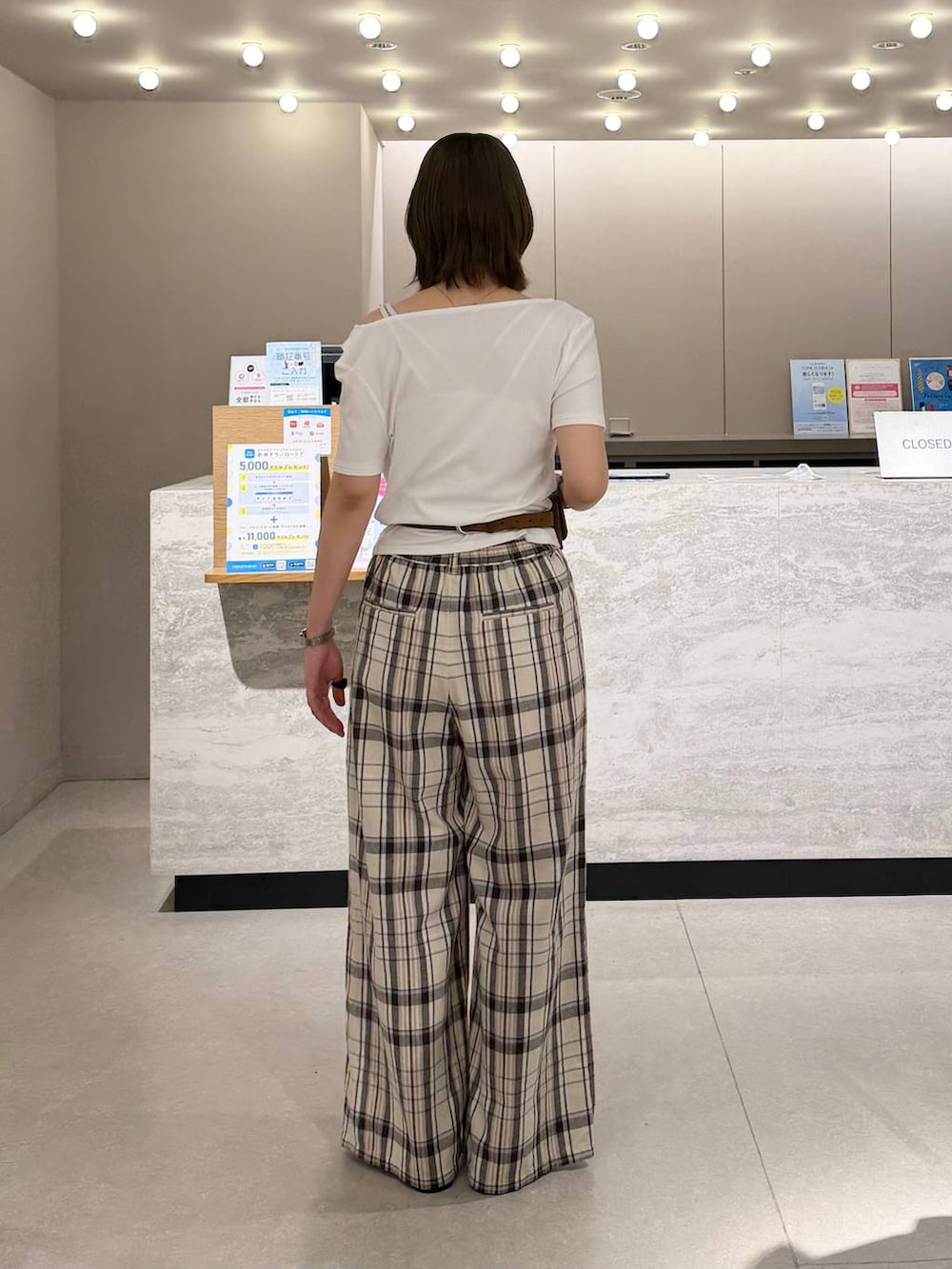 ホワイト系のTシャツ/カットソー、ベージュ系のスラックス、ブラック系のサンダルを着用したレディースの夏コーディネートの3枚目の写真